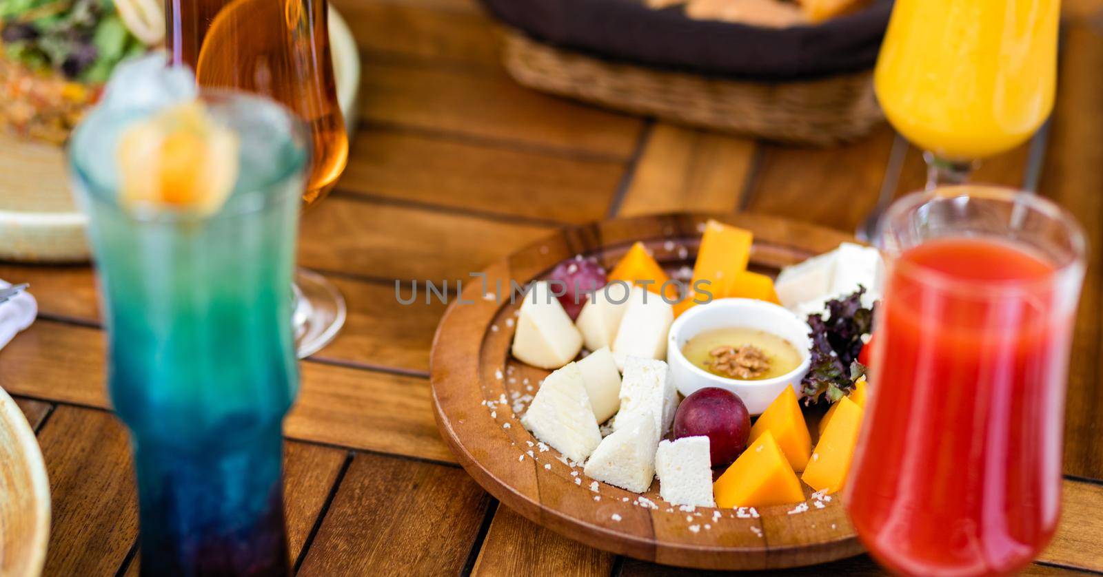 Assorted cheese with sauce on the wooden plate by ferhad