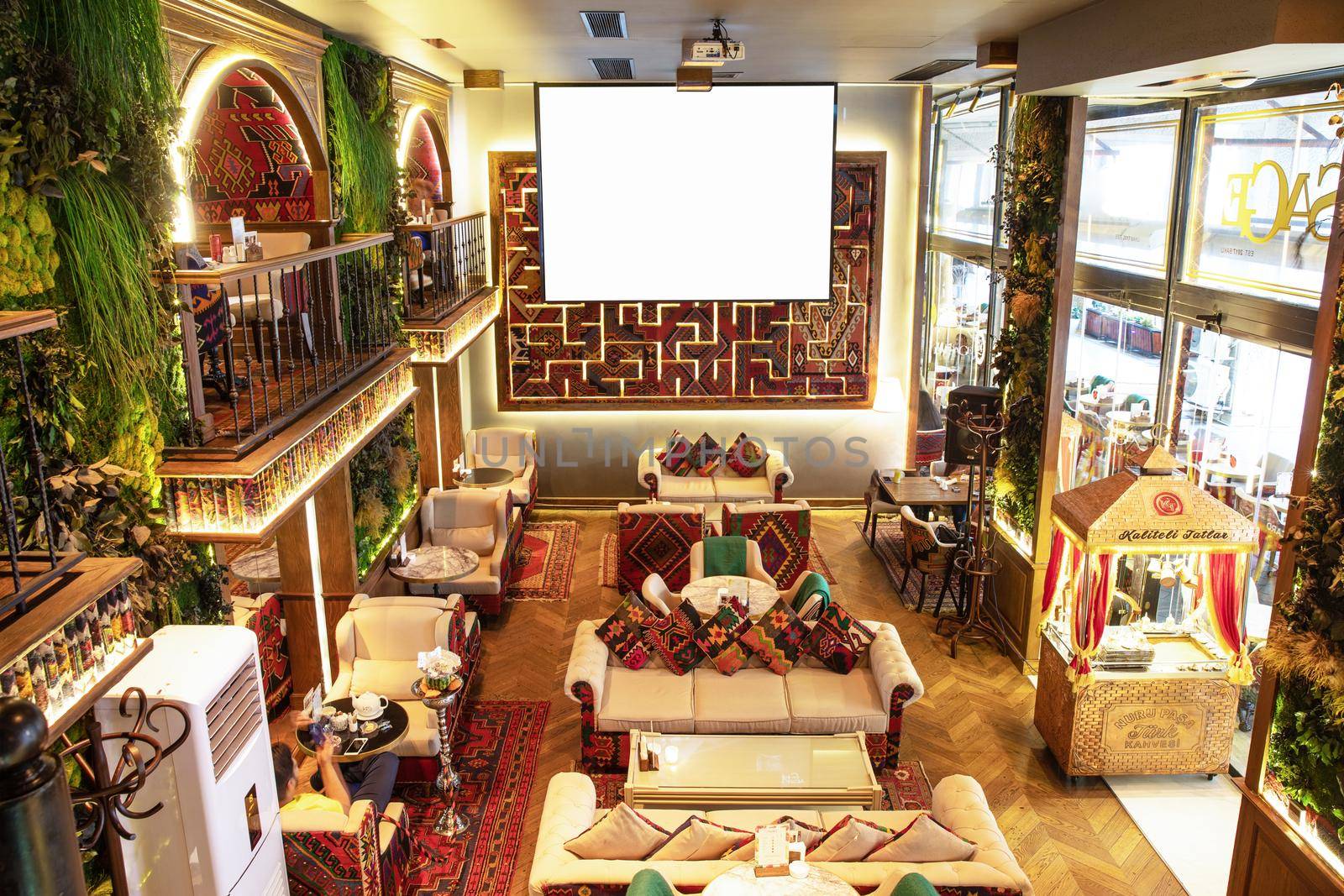 Cozy old style interior of restaurant, teahouse with white projector screen by ferhad