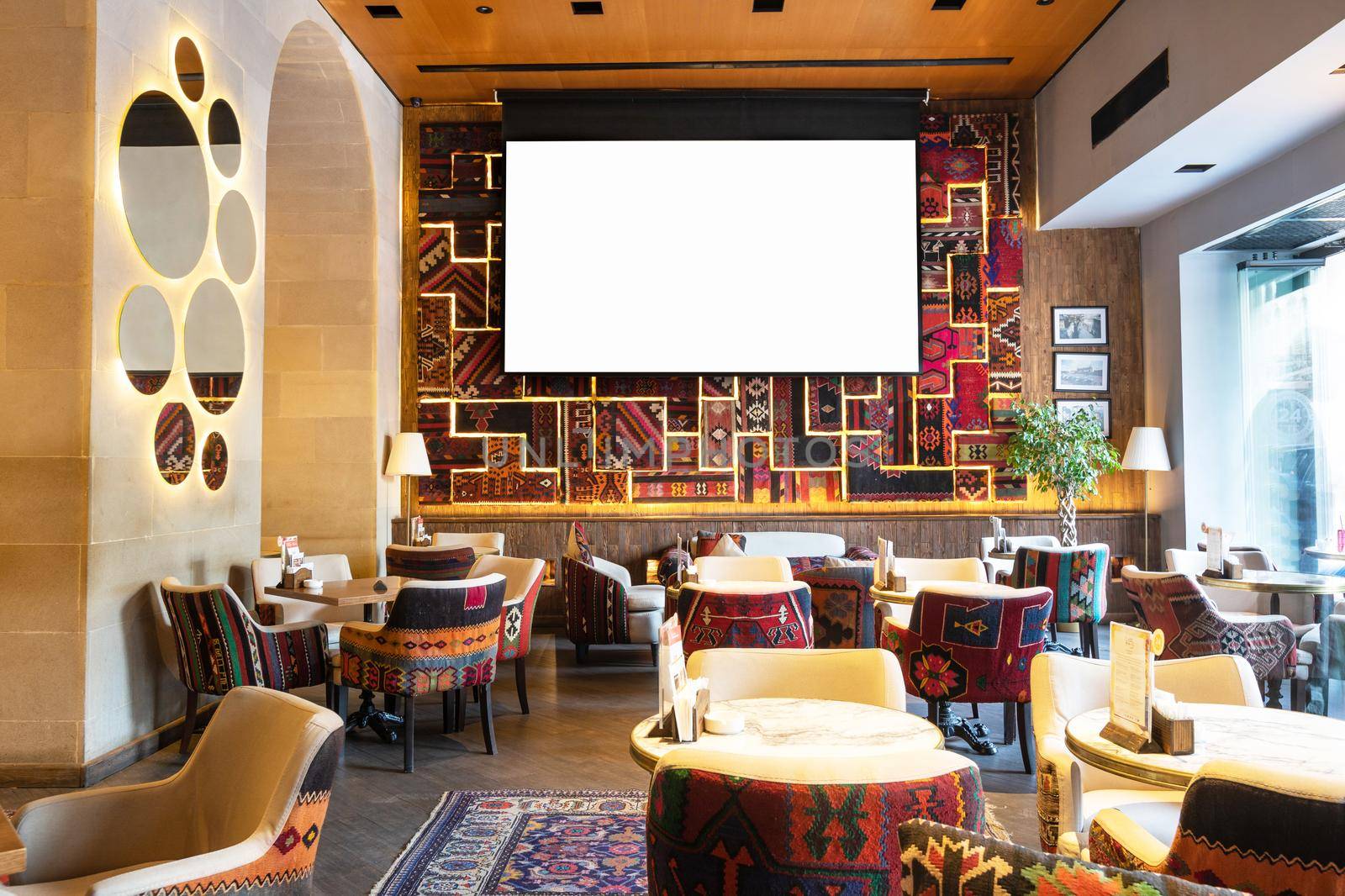 Cozy old style interior of restaurant, teahouse with white projector screen by ferhad