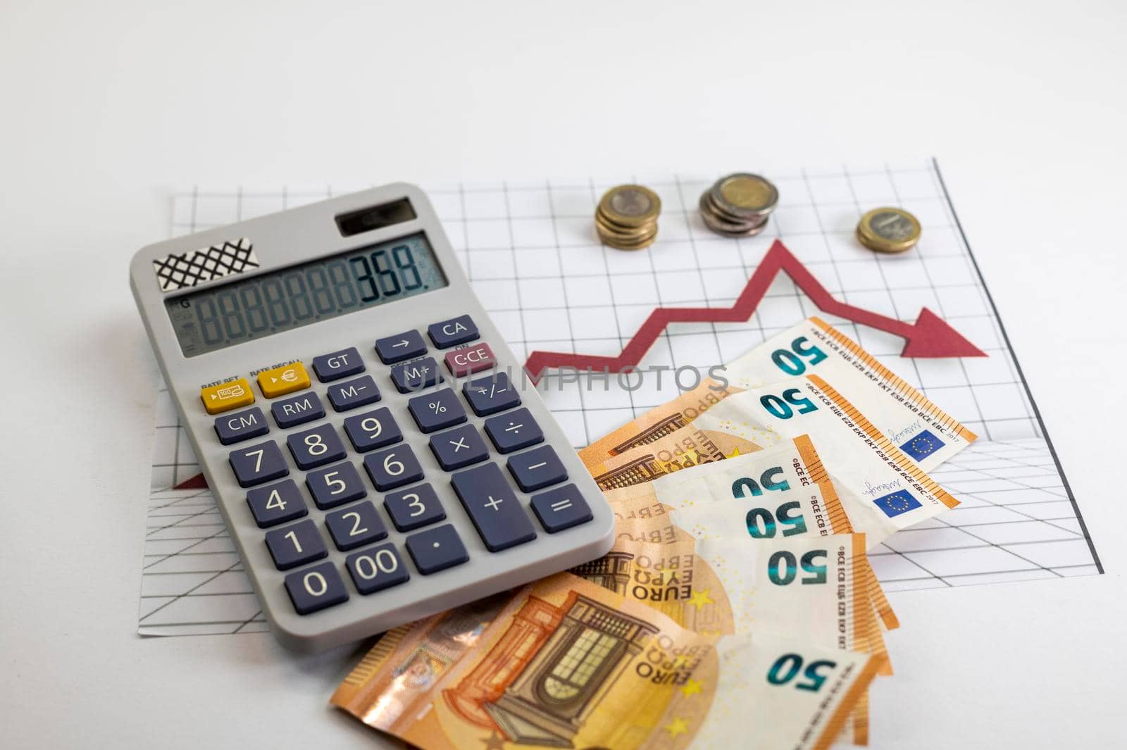 euro coins and banknotes with calculator and statics as background