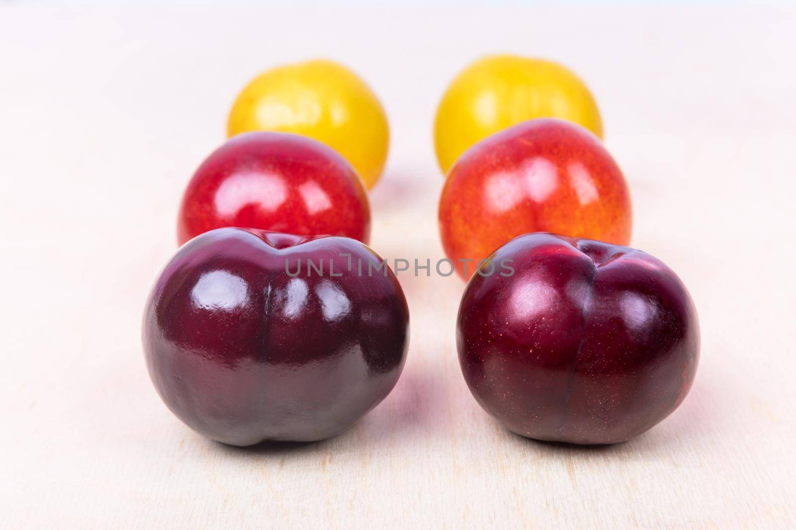 Red, yellow plum fruit close up on the white background isolated