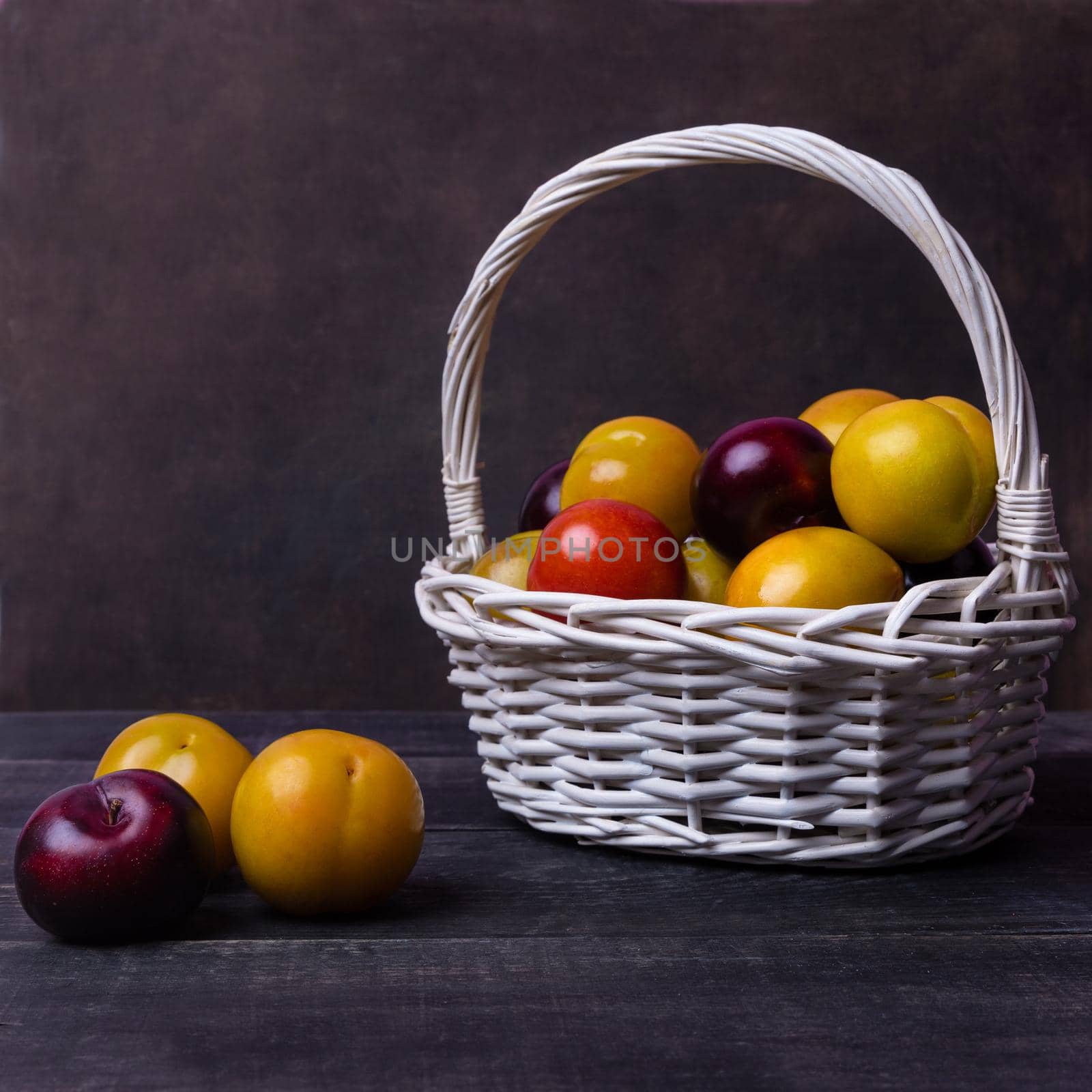 Colorful plums fruit in basket on the black background isolated by ferhad