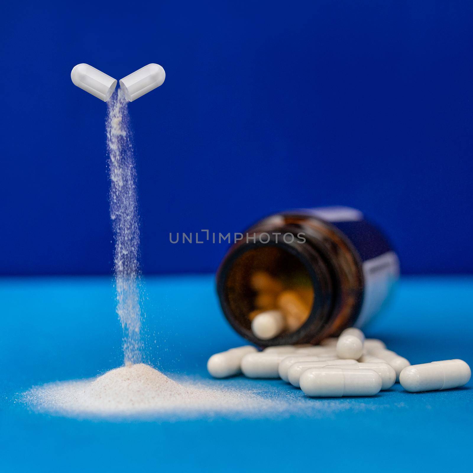 Capsule drug pouring down with a lot of white capsules, pills