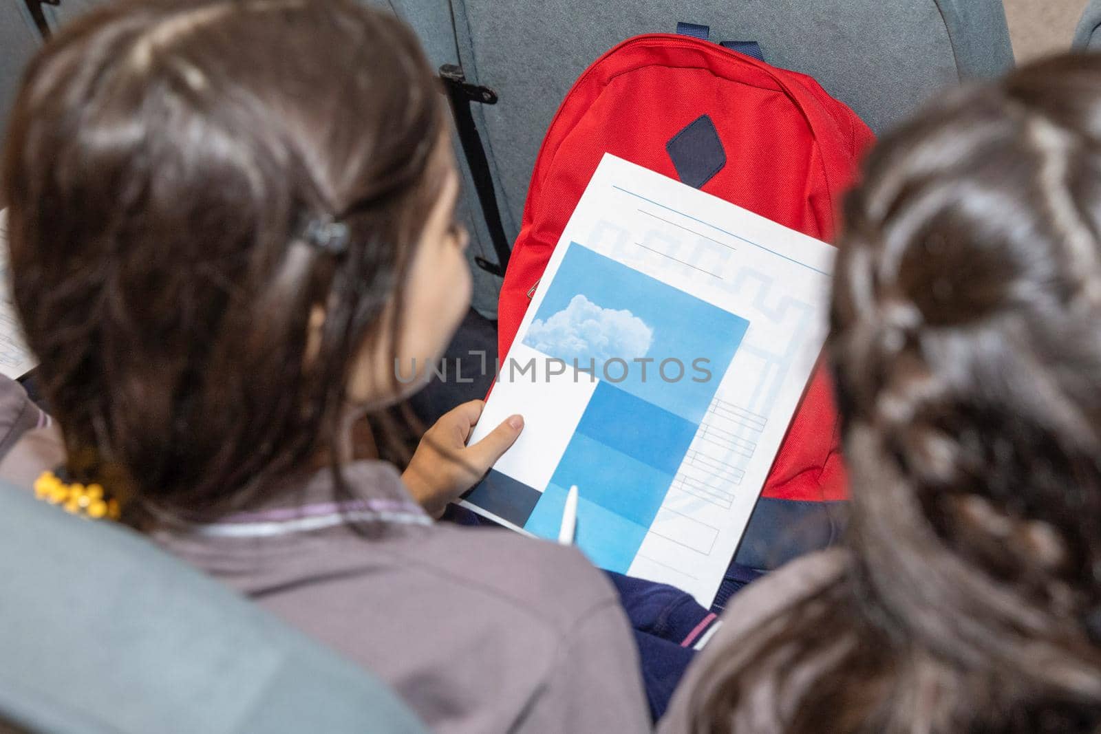 School girl holding a paper document top view