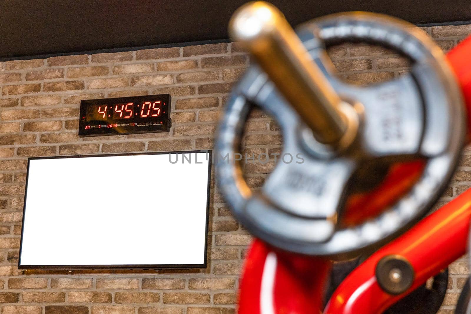 Barbell at workout gym, wall clock