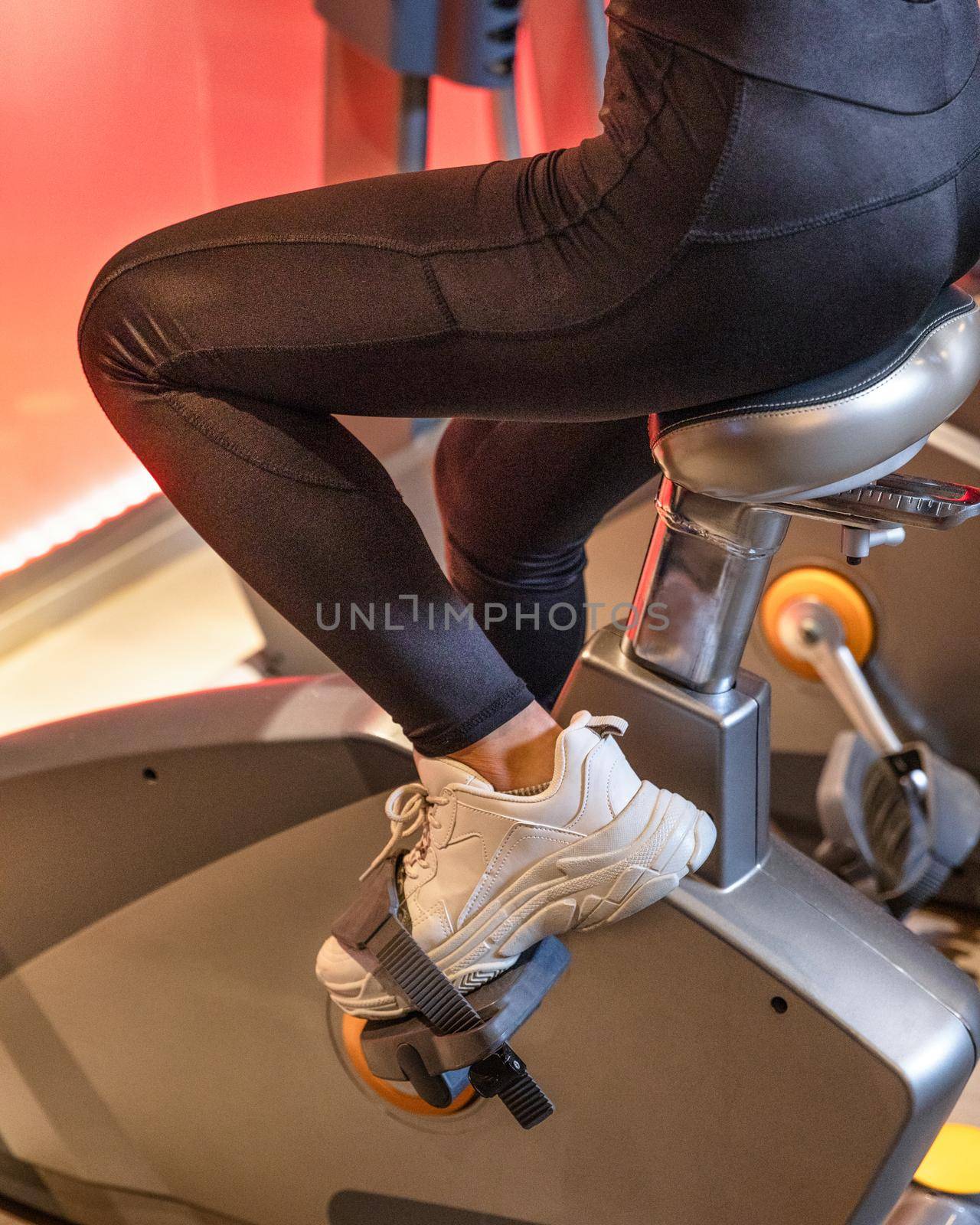 Cropped shot of fitness woman working out on exercise bike at the gym by ferhad