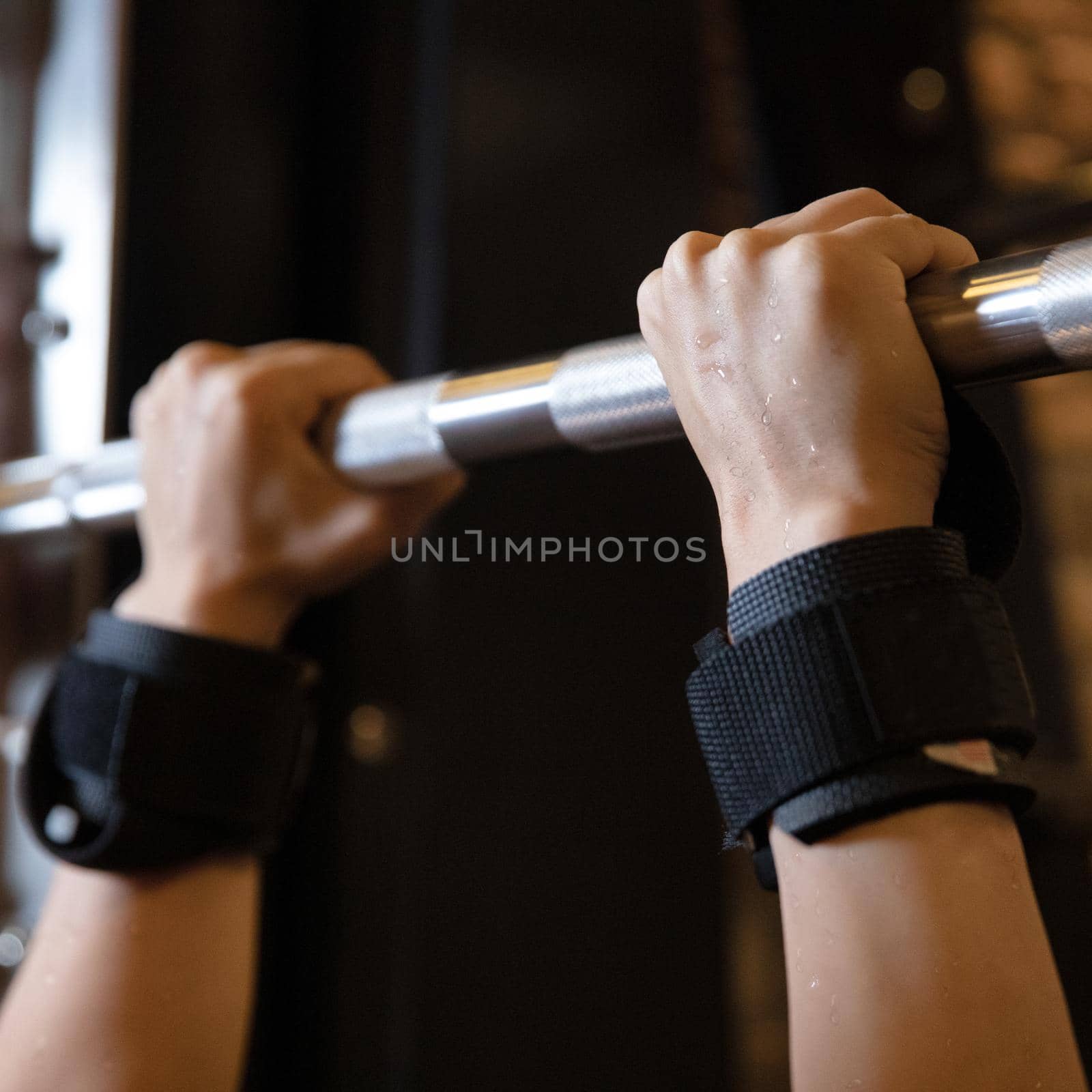 Woman sweaty hands, execute exercise on horizontal bar in gym by ferhad