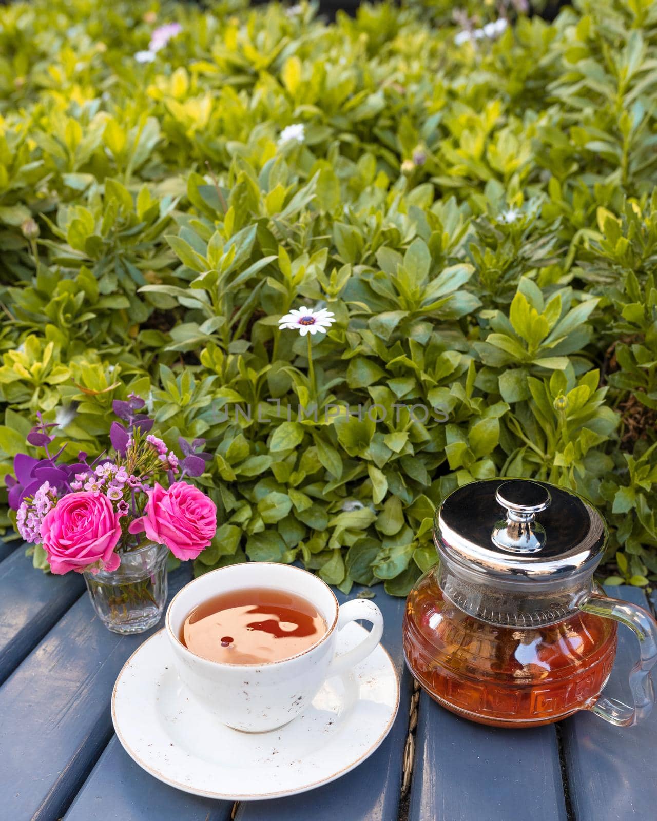 Teapot, tea cup with flower, green background