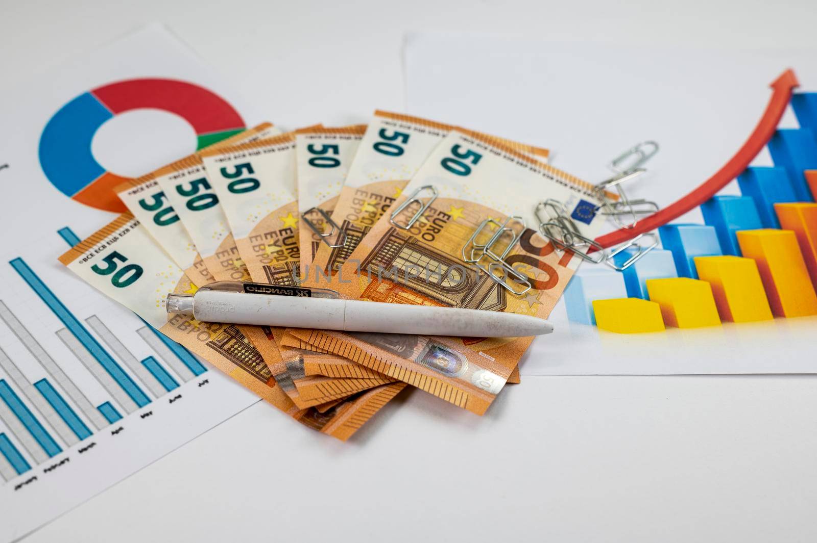 50 euro bills with statistics and a pen on a white background