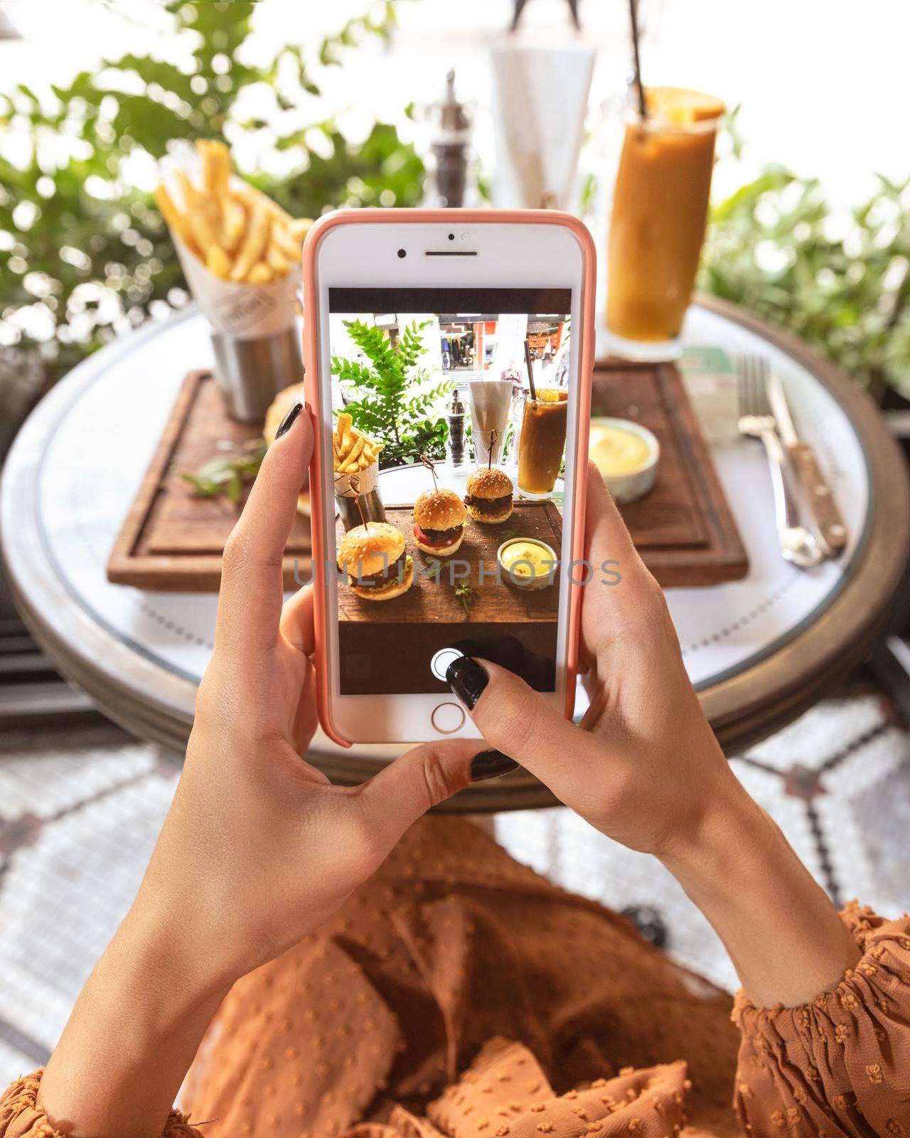 Woman taking picture of a burger menu at restaurant