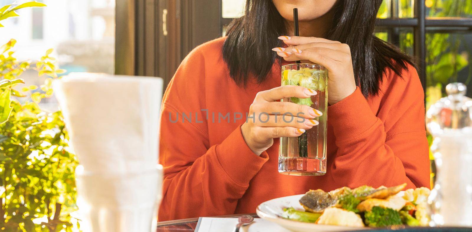Woman drinking cocktail with fish meal