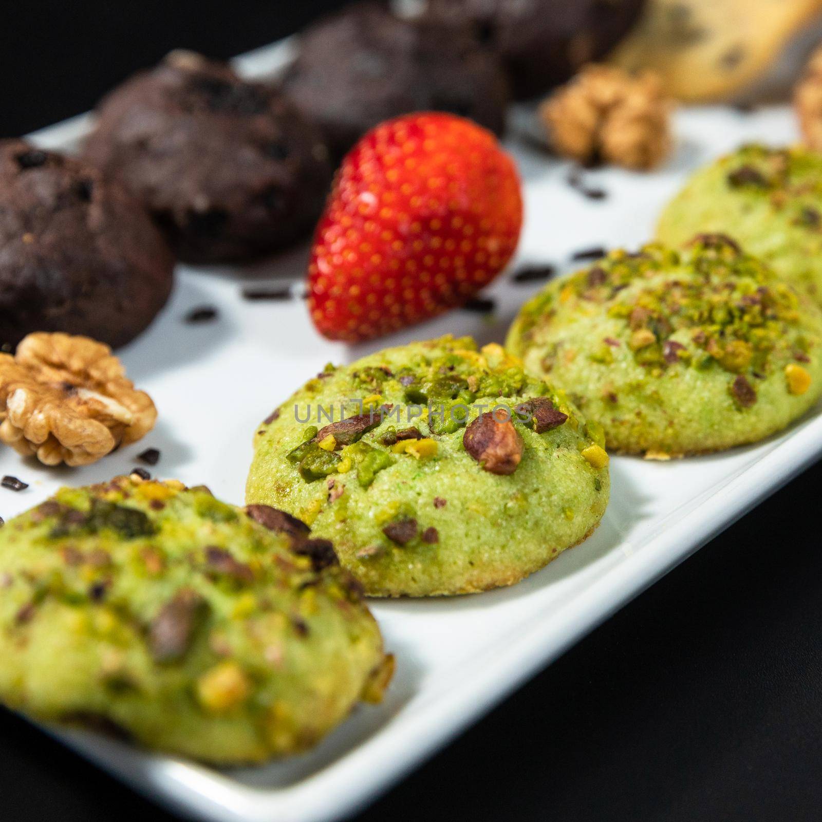 Tasty colorful chocolate cookies on the black background