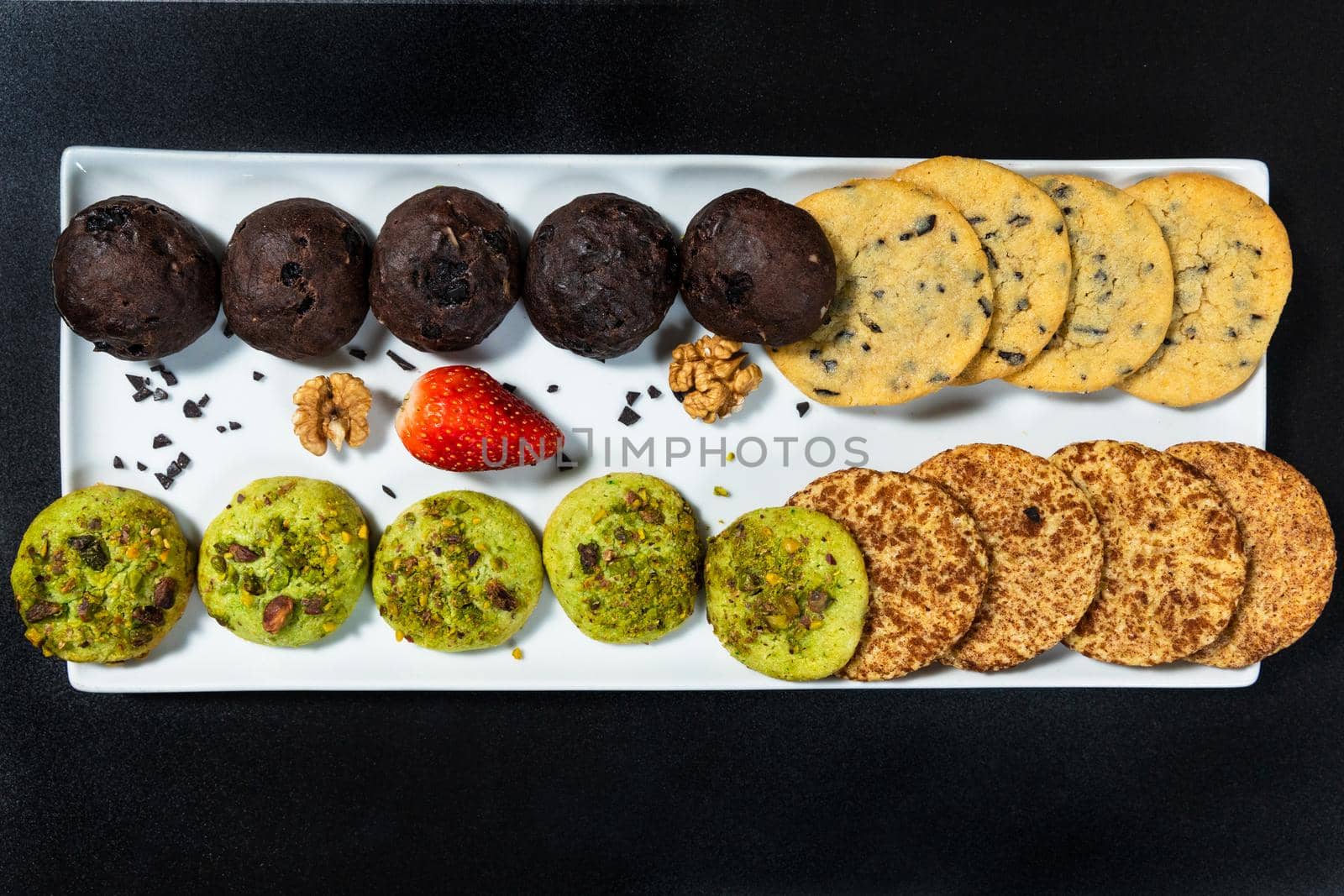 Tasty colorful chocolate cookies on the black background, top view by ferhad