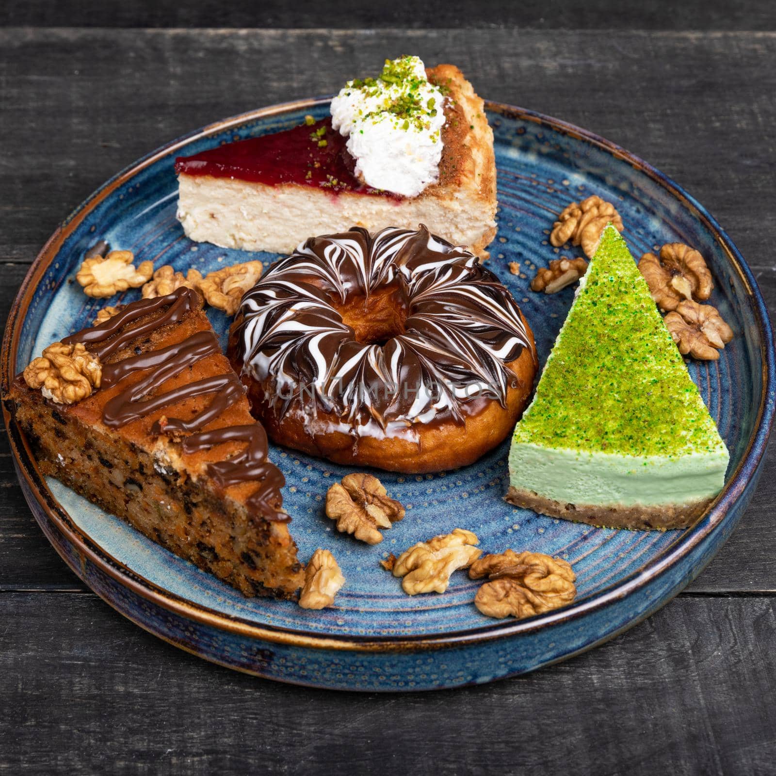 Beautiful doughnut, chocolate cake, tiramisu on the blue plate by ferhad