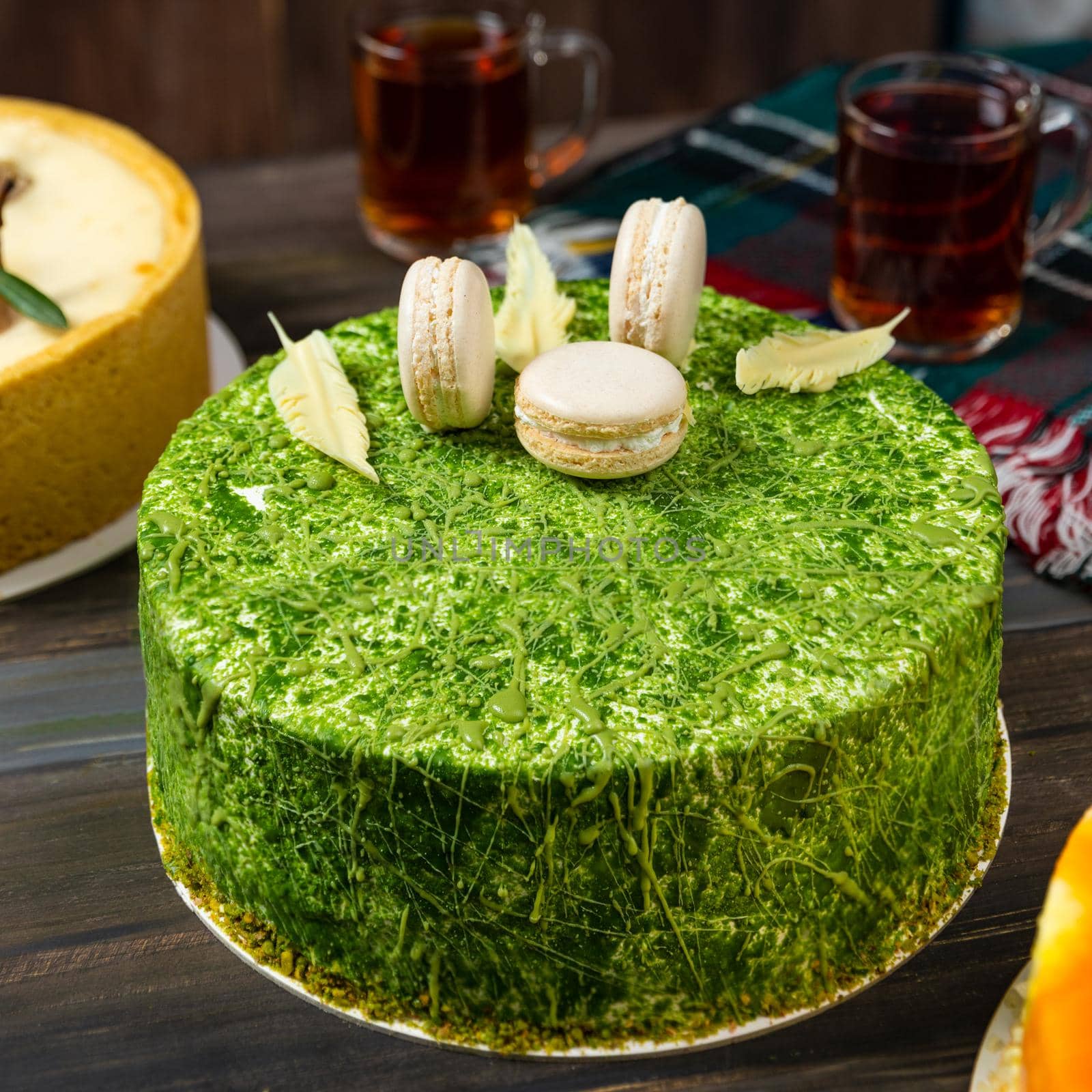 Different beautiful macaron cake on the wooden table with tea