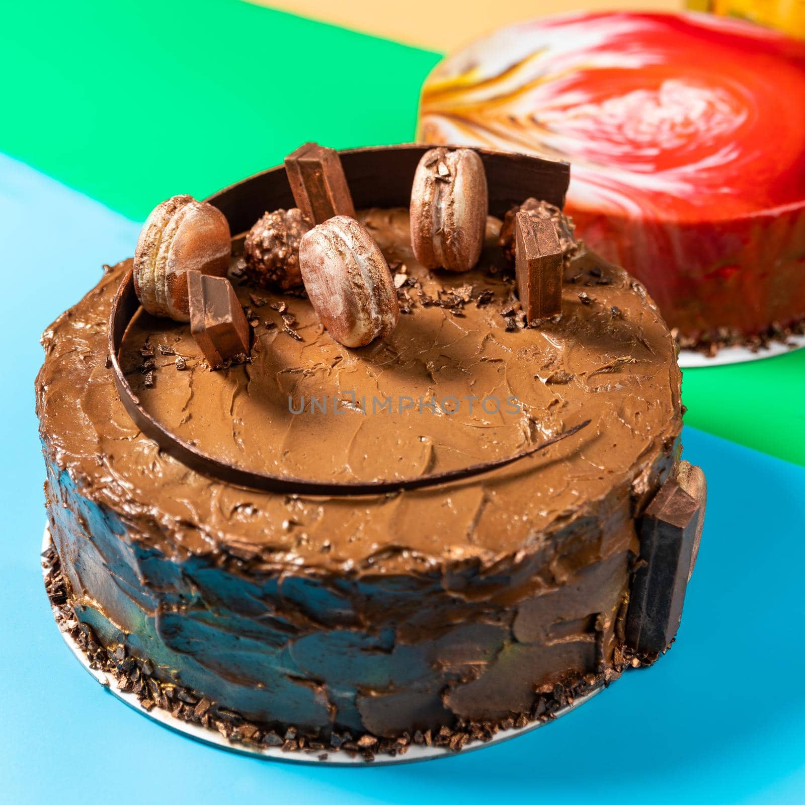 Different beautiful chocolate macaron cake on the colorful background