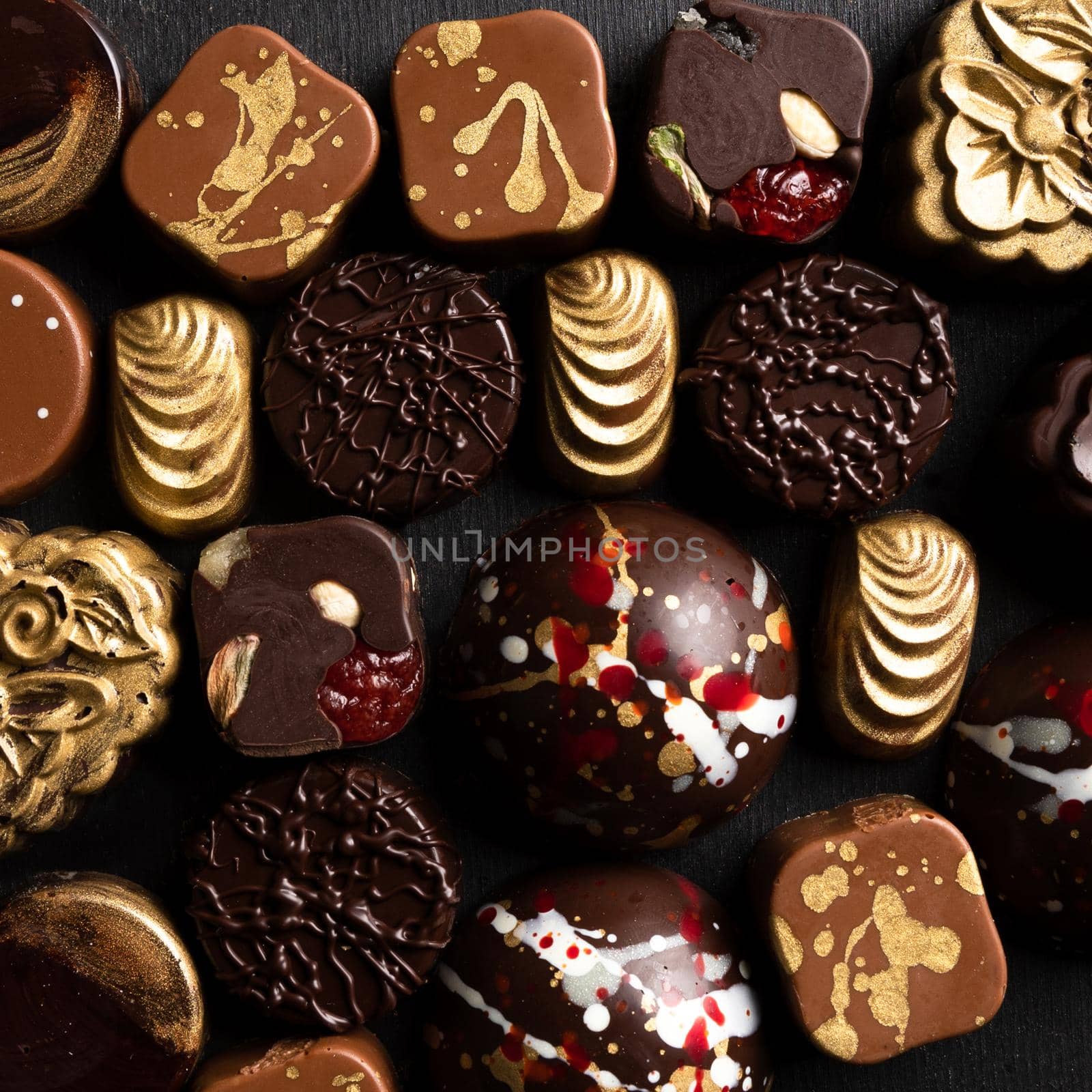 Luxury chocolate pieces on the black background, top view