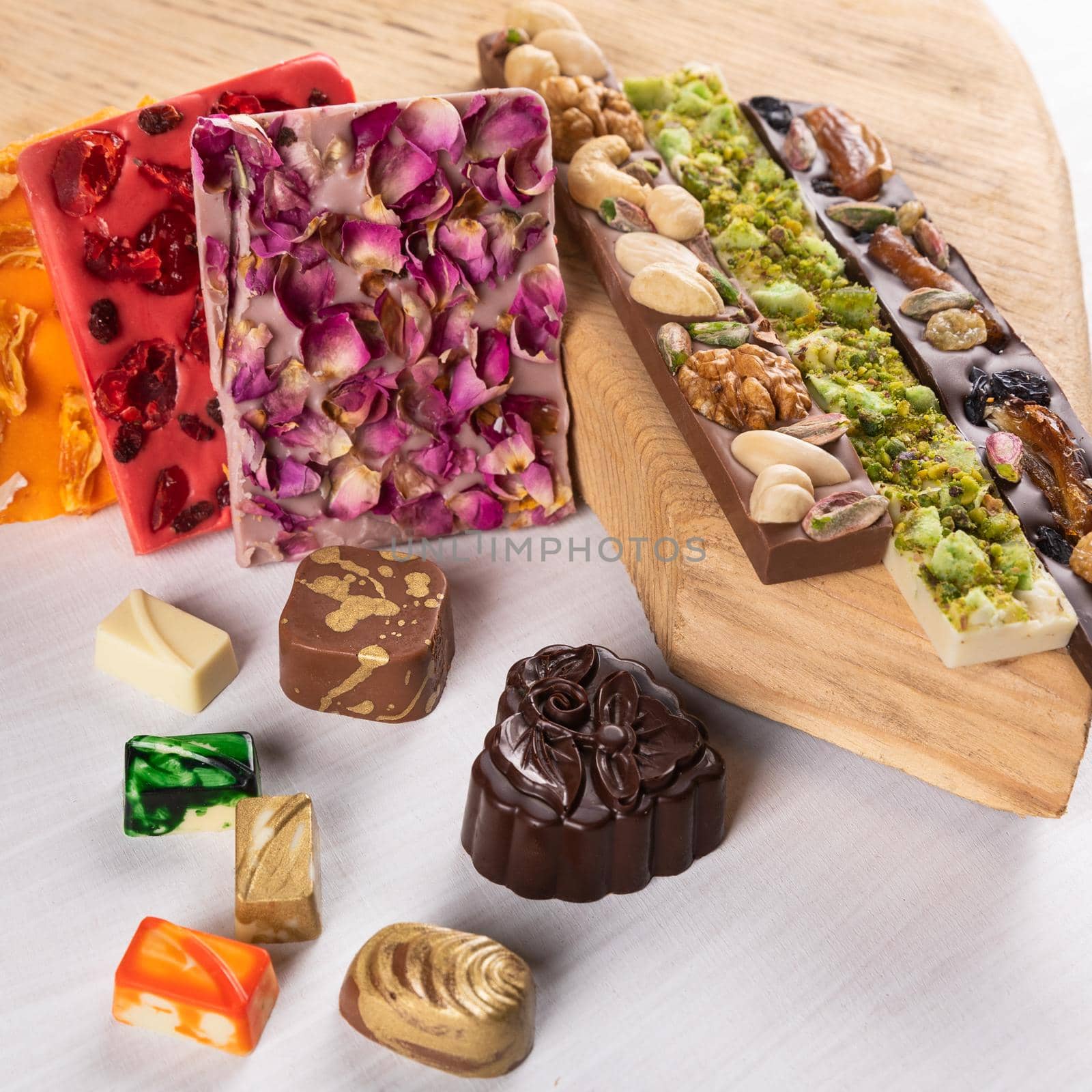 Luxury chocolate pieces, rose, pomegranate, nuts close up by ferhad