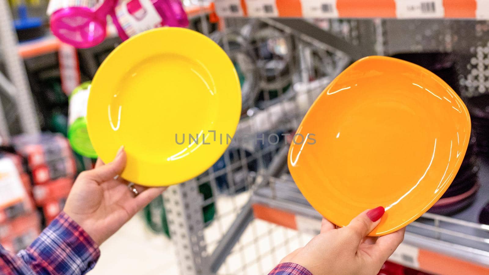 Woman holding a colorful kitchen plate at the store