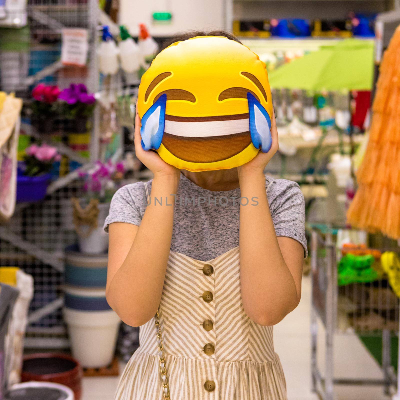 Woman holding a laugh emoji pillow