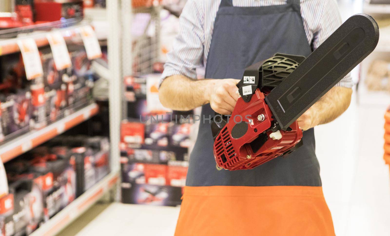 Man holding new chainsaw at the store by ferhad