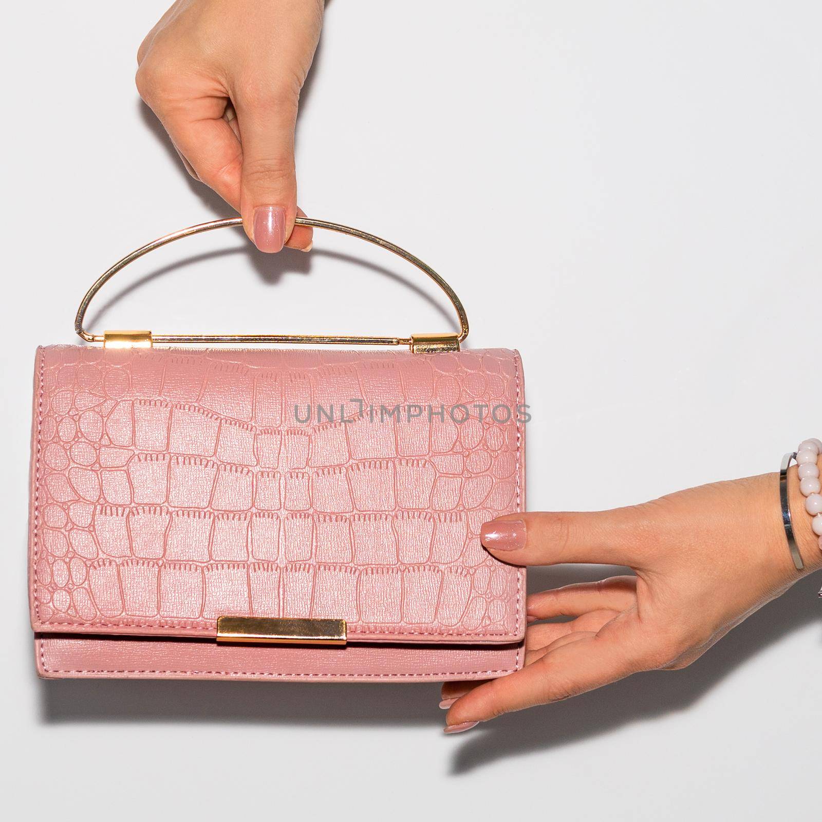 Woman holding pink leather handbag close-up