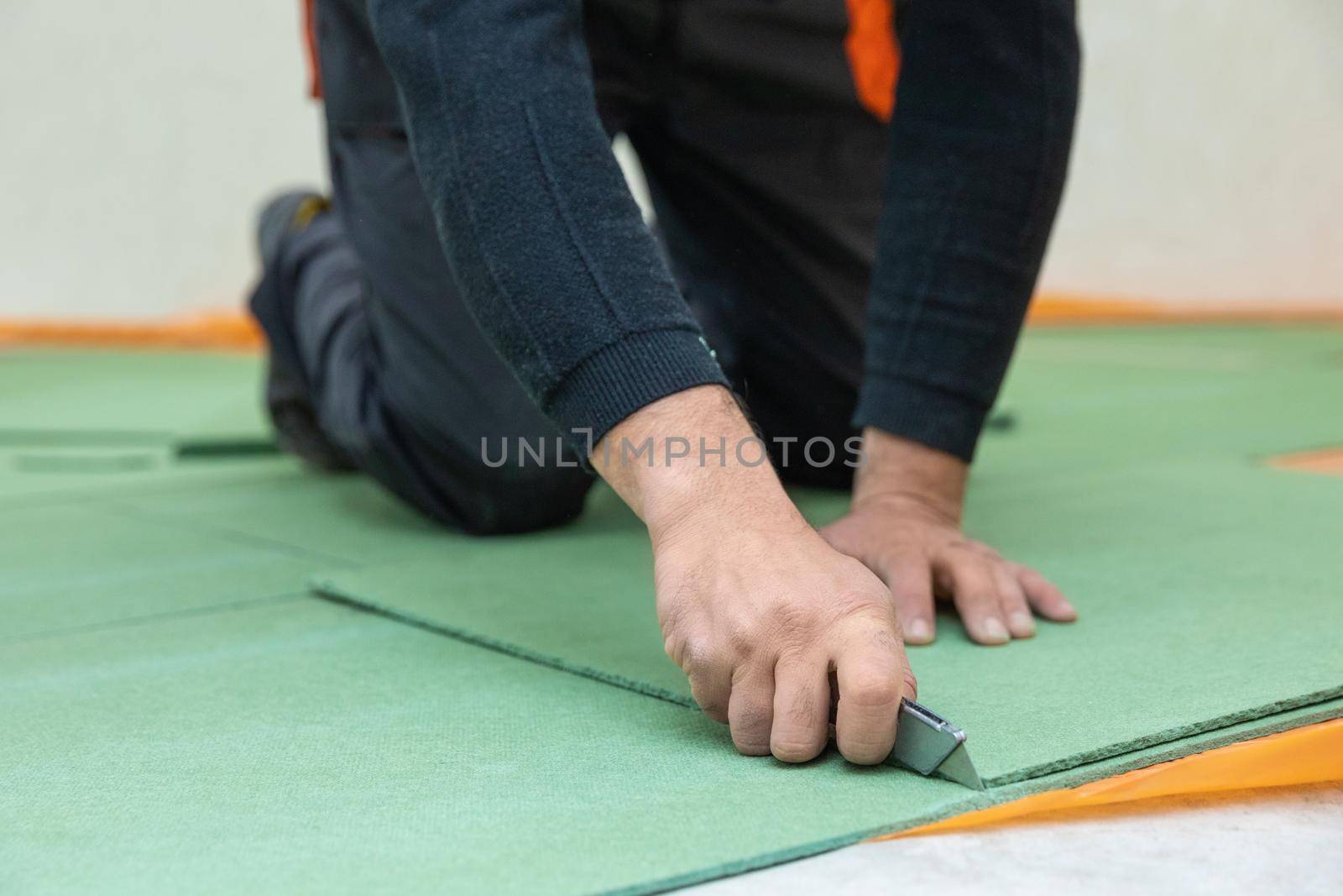 Worker cutting underlayment for flooring