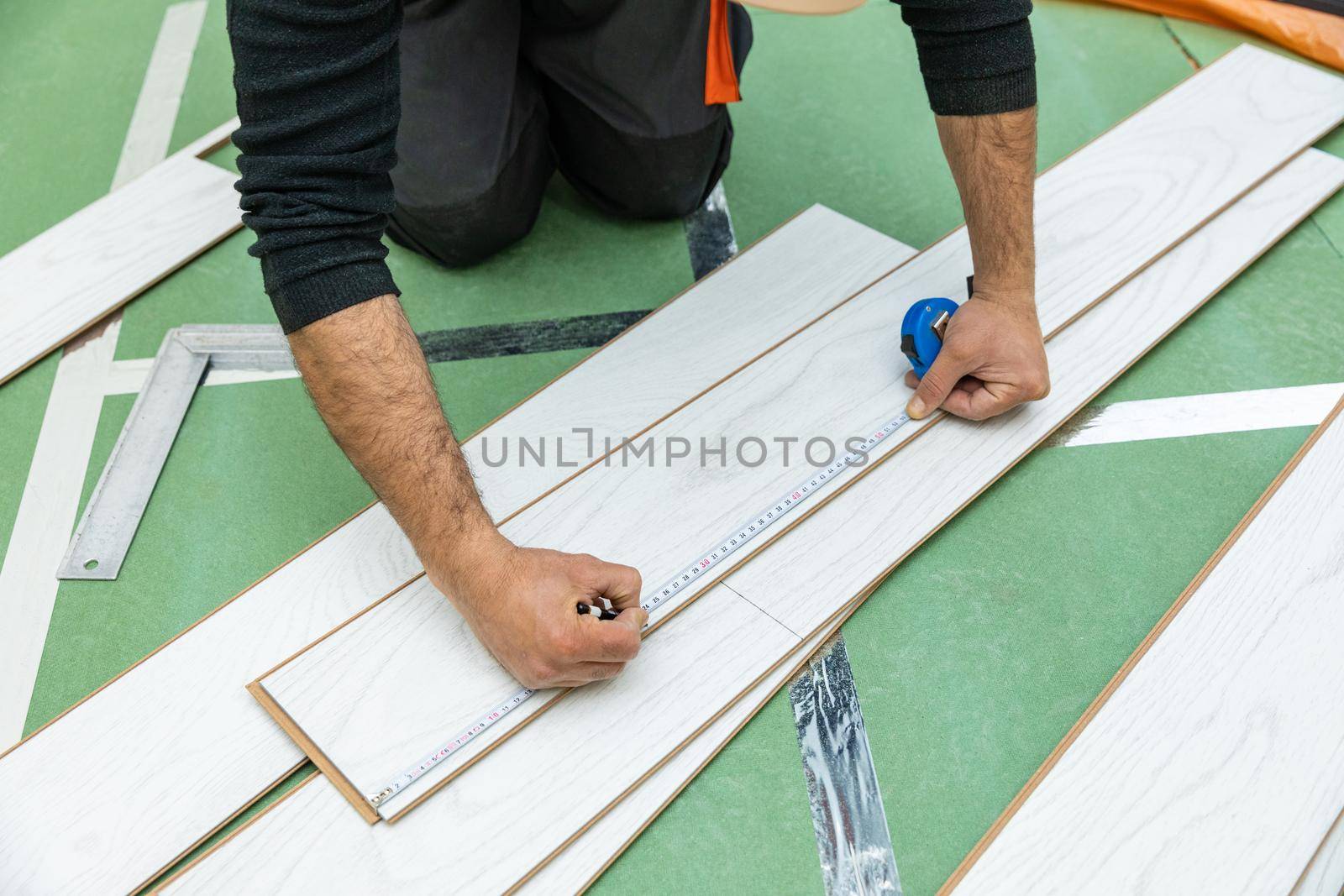 Worker measure length of the white wood laminate by ferhad