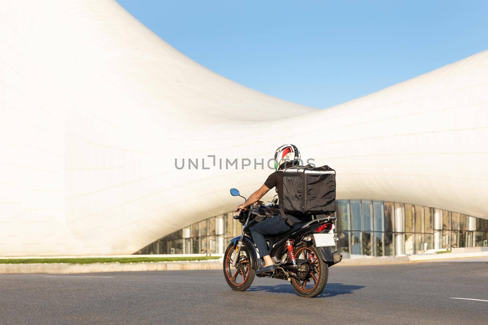 Courier worker driving a motorcycle in the city