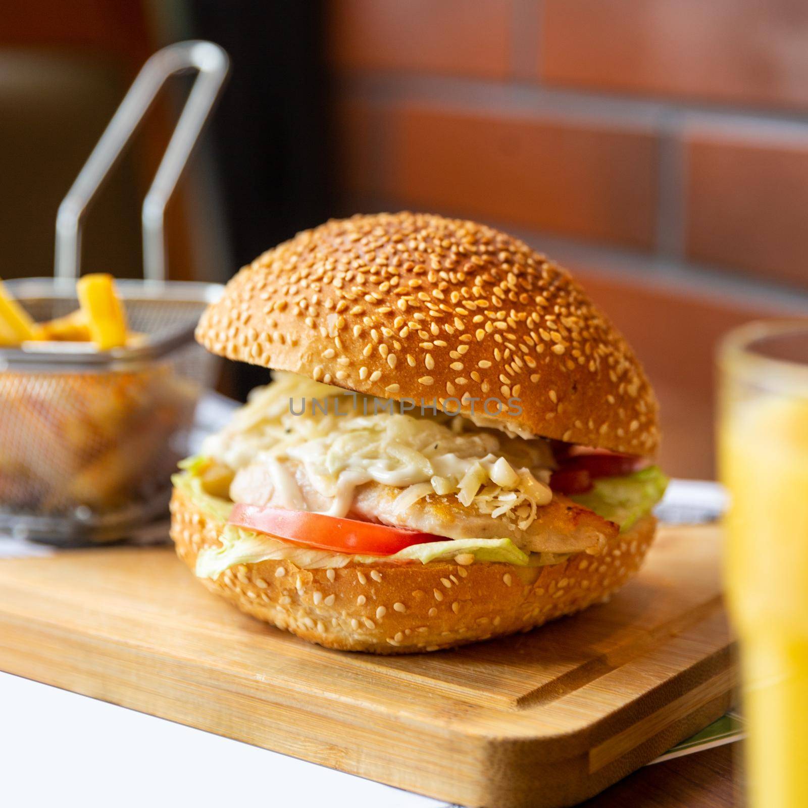 Caesar burger with french fries on the wood plate