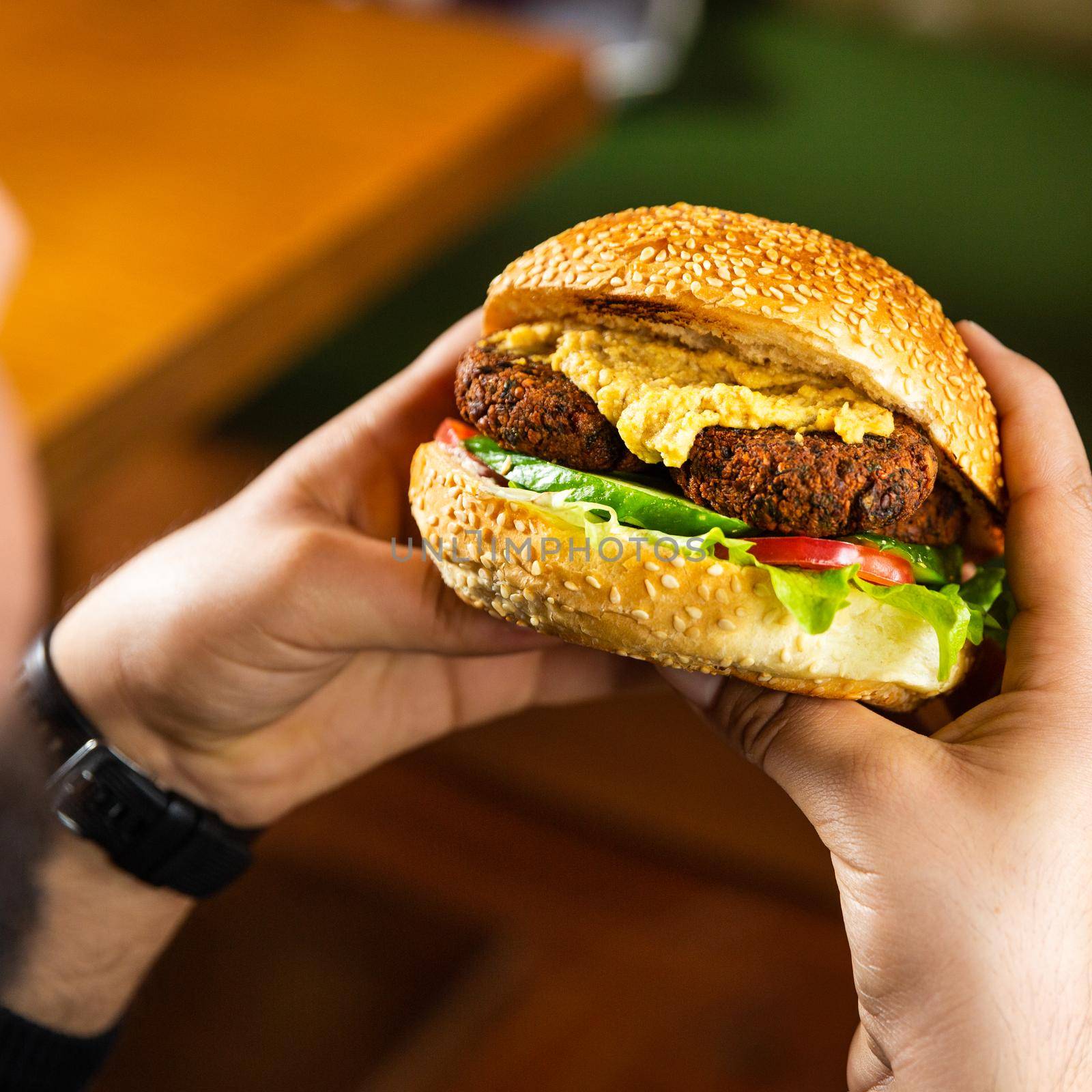 Man holding Vegetarian, Veggie burger by ferhad