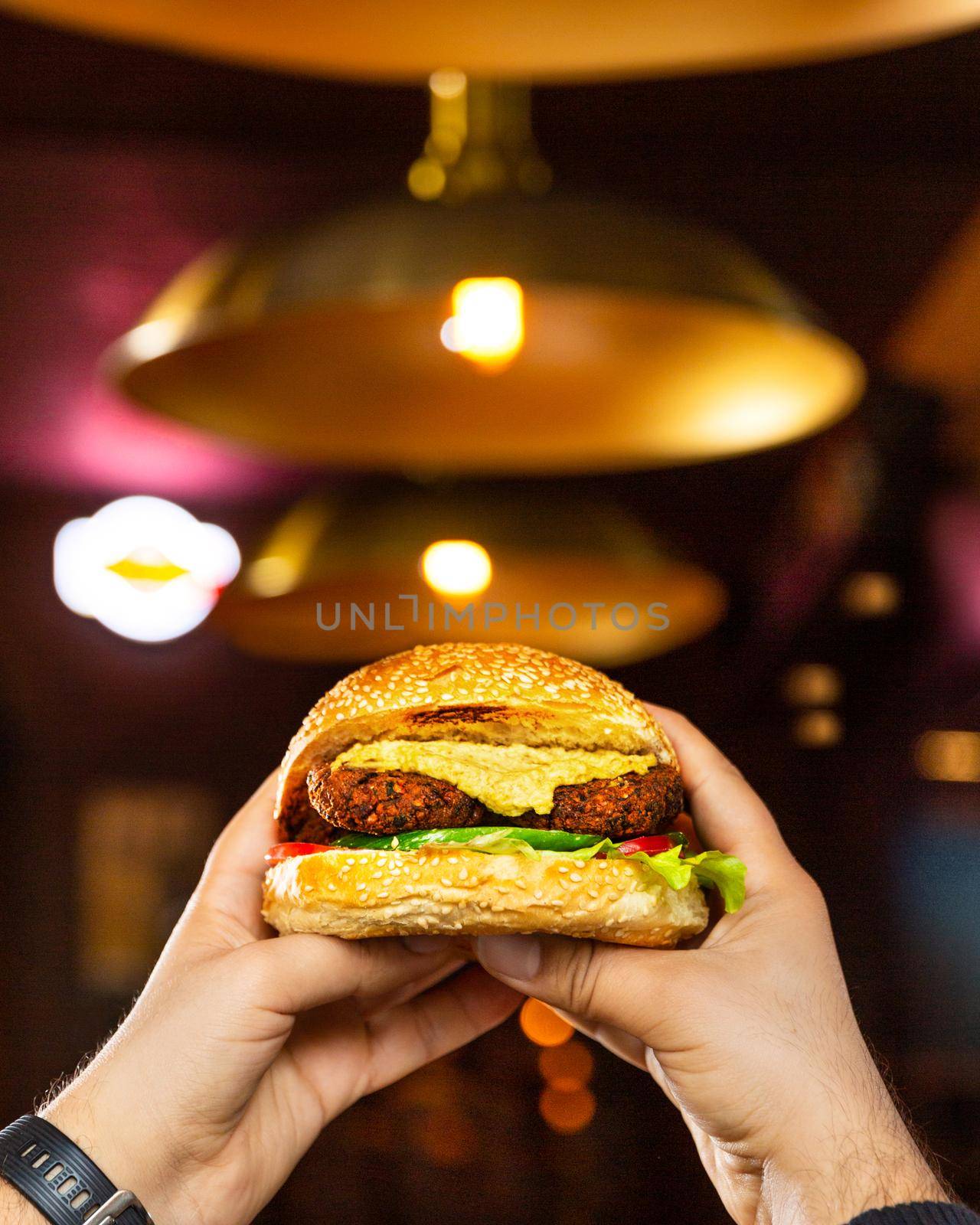 Man holding Vegetarian, Veggie burger by ferhad