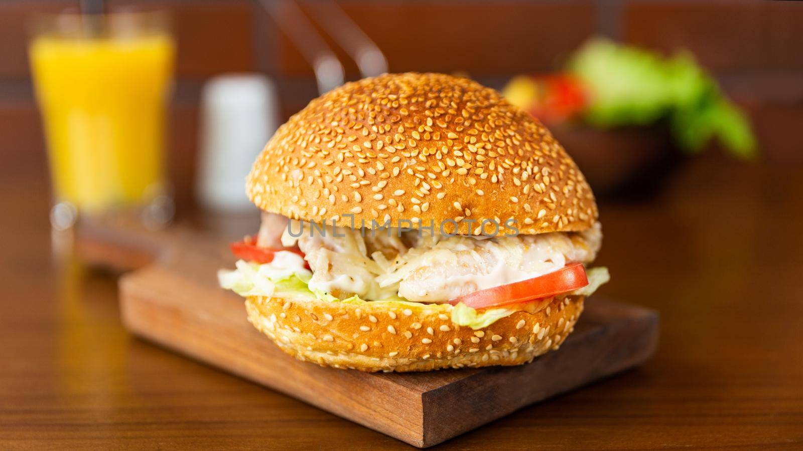 Caesar burger, french fries on the wood plate close up