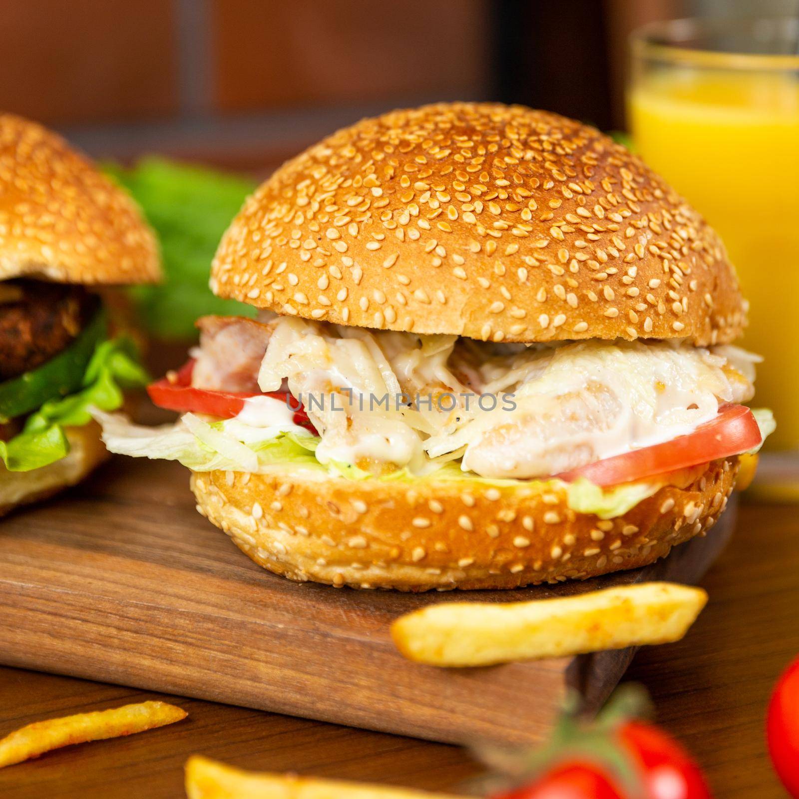 Caesar burger, french fries on the wood plate close up by ferhad