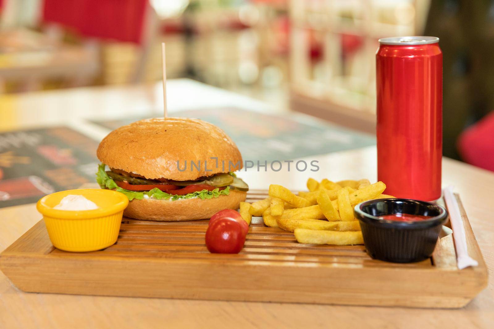 Tasty burger with french fries, ketchup and soda