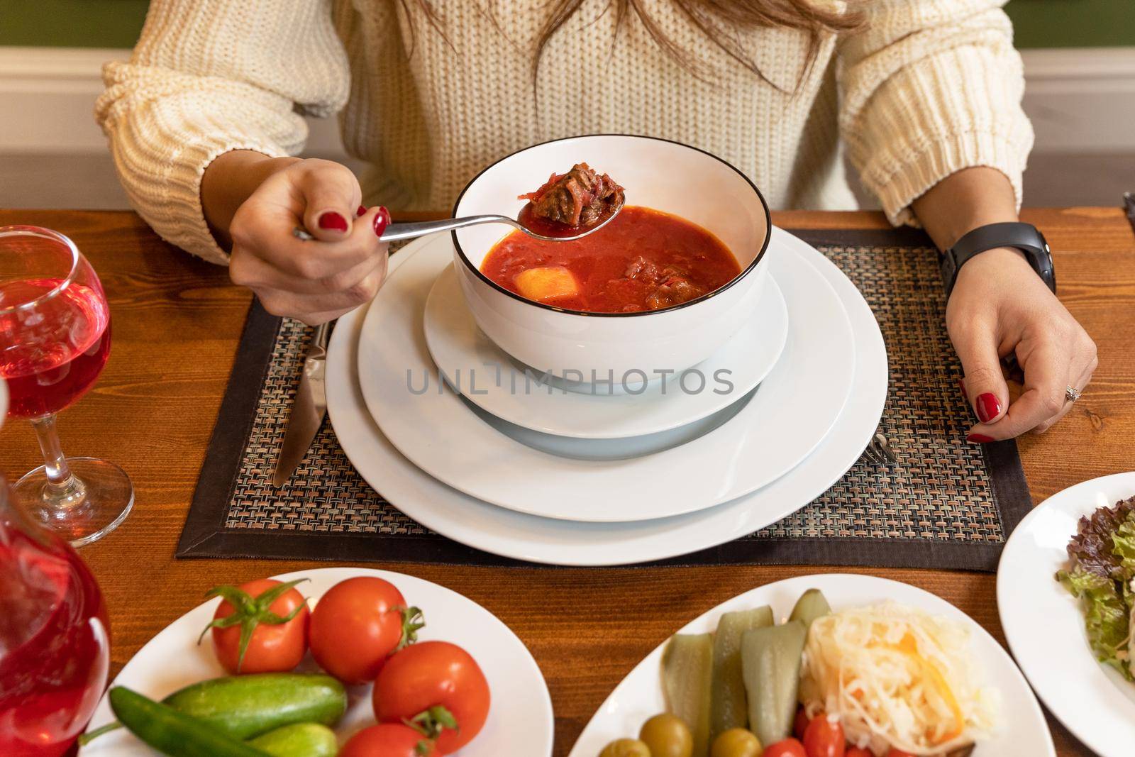 Woman eating tasty red borscht soup