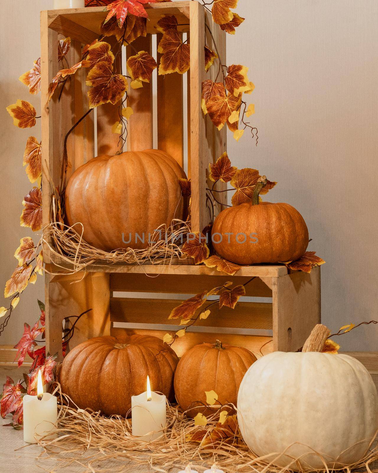 Halloween Pumpkins in the wooden crates with candles, straw, autumn leaves by ferhad