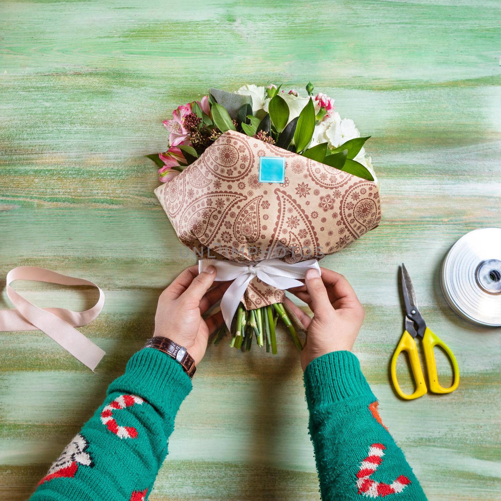 Florist making flower bouquet on the table by ferhad