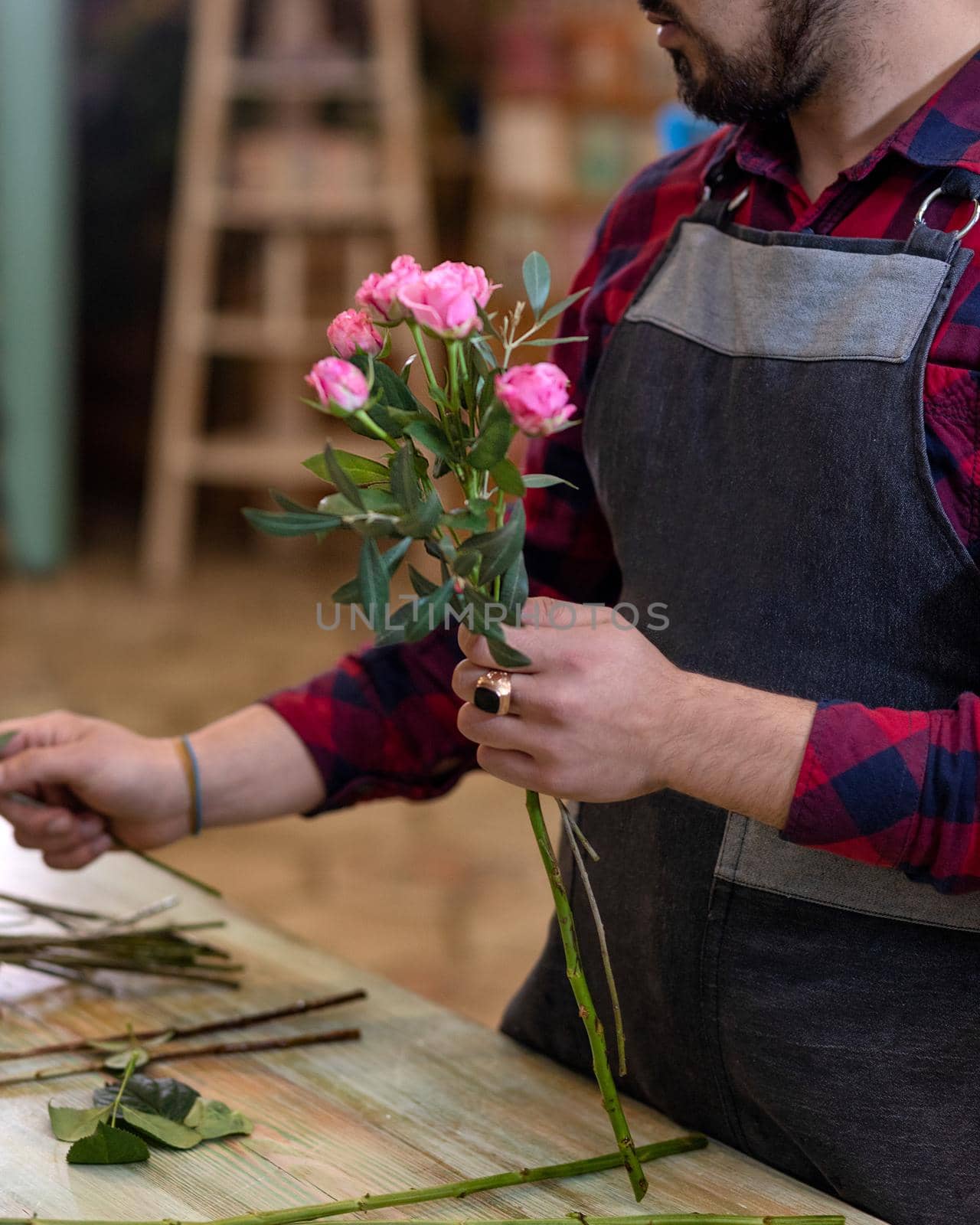 Florist man making flower bouquet at the store