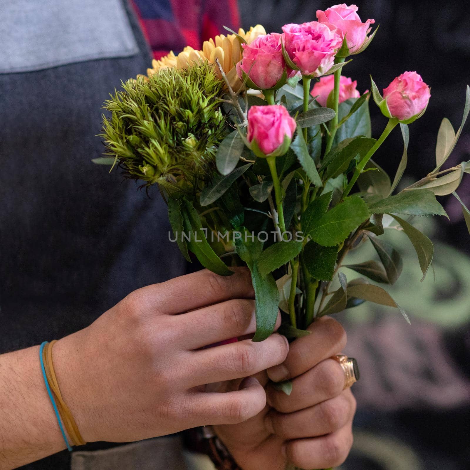 Florist man making flower bouquet at the store