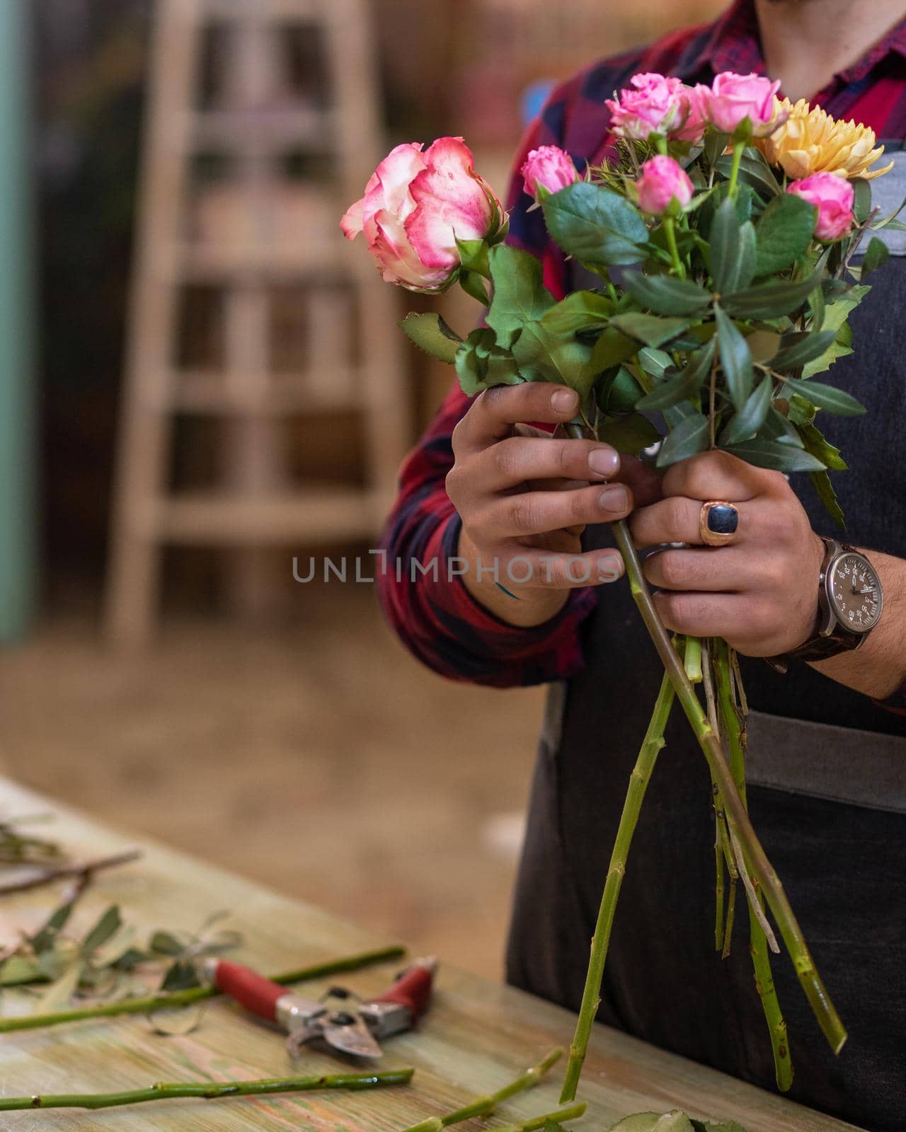 Florist man making flower bouquet at the store