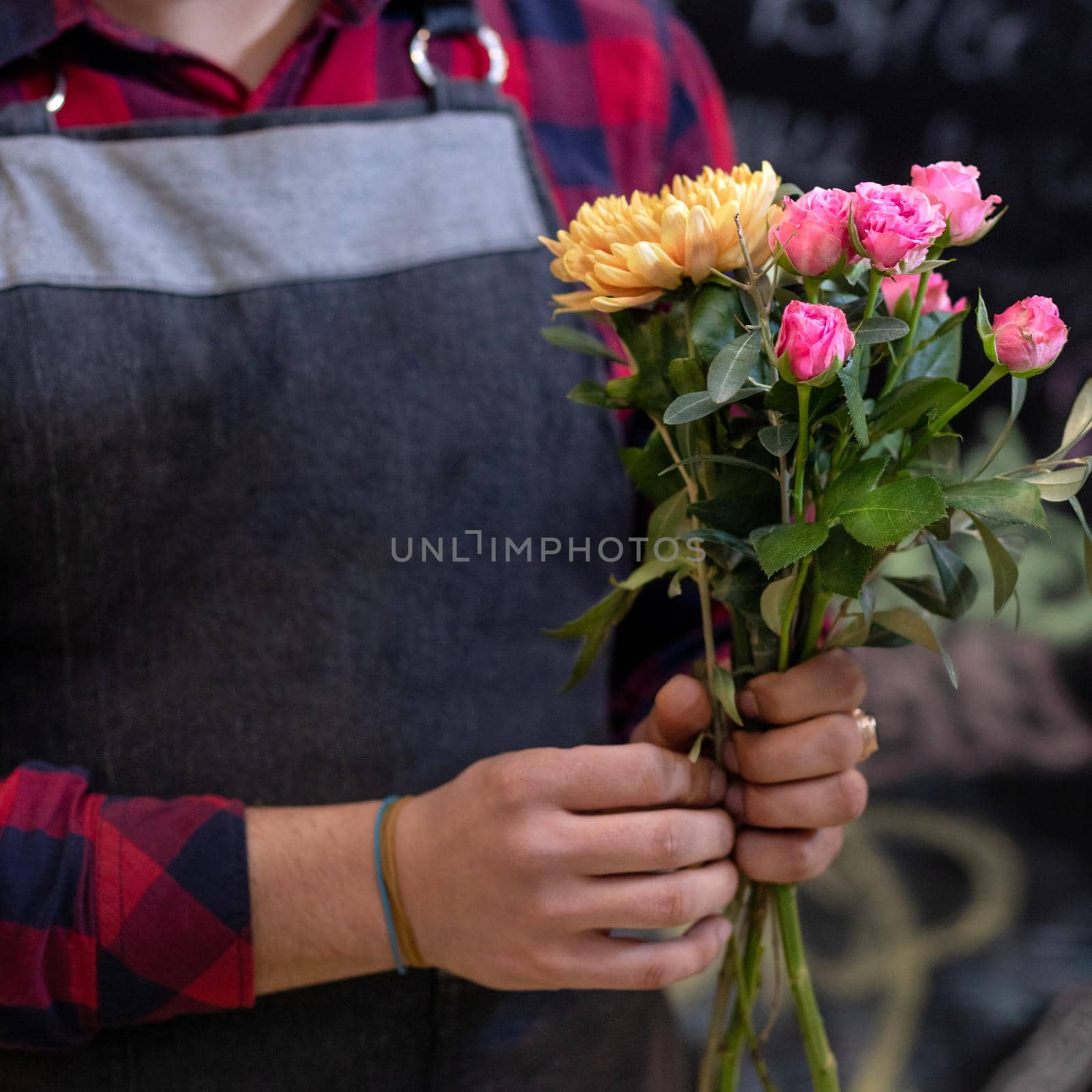 Florist man making flower bouquet at the store