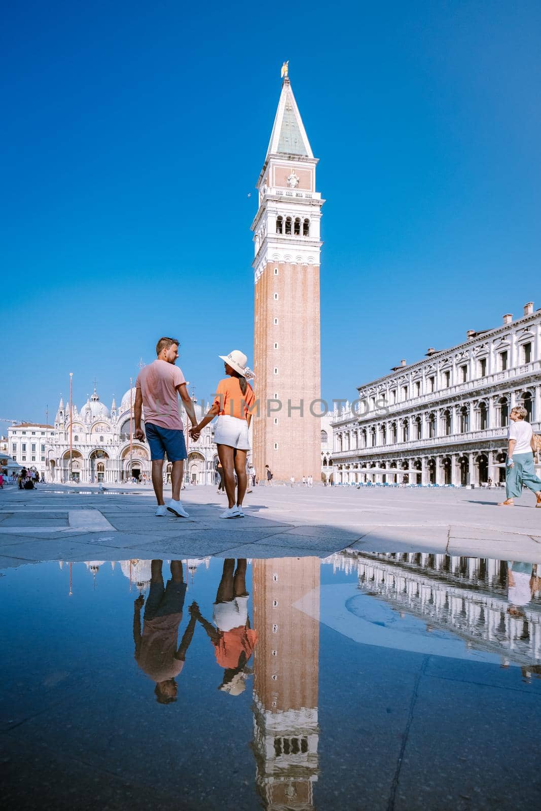 couple men and woman on a city trip to Venice Italy, colorful streets with canals Venice. Europe