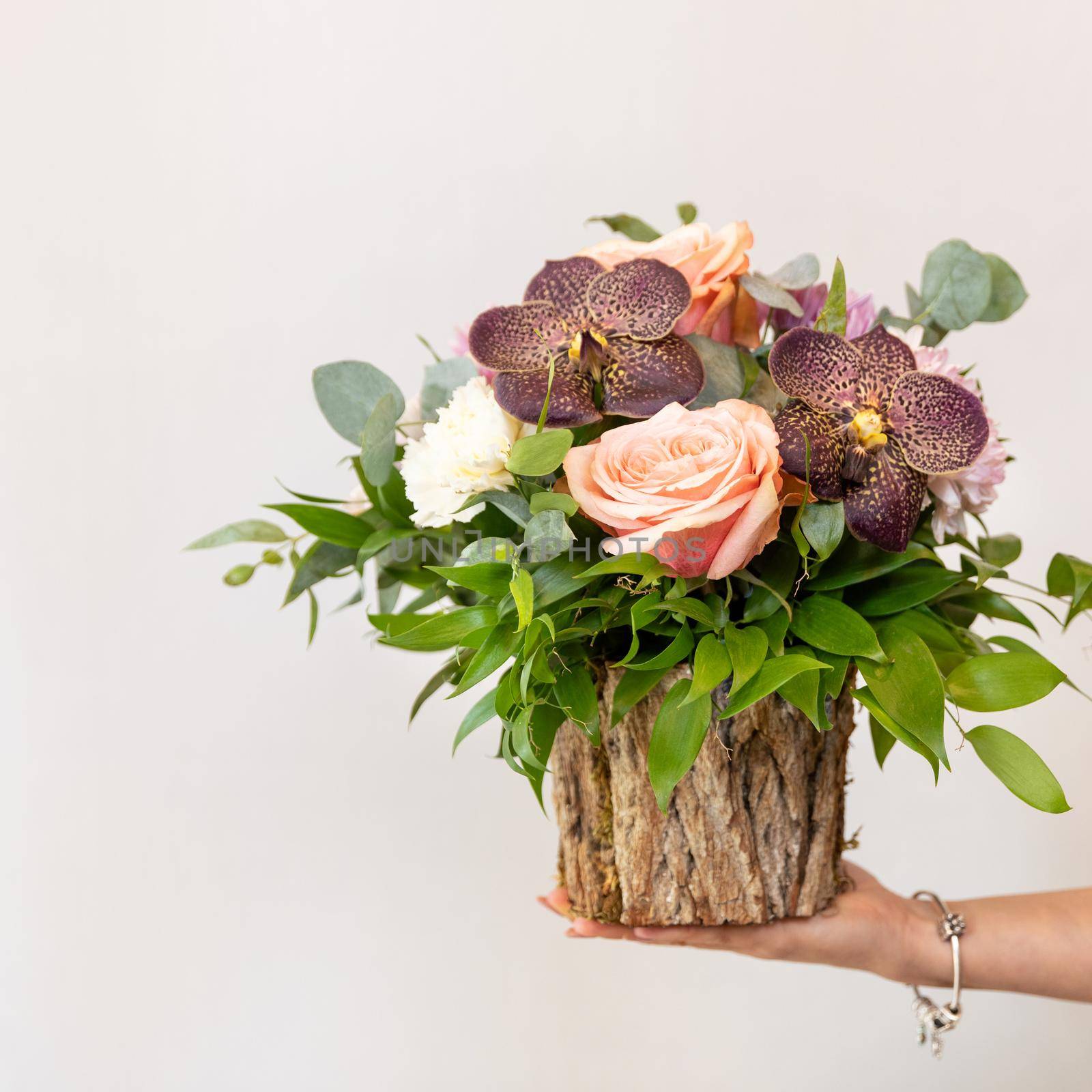 Woman holding beautiful flower bouquet in the wooden pot by ferhad