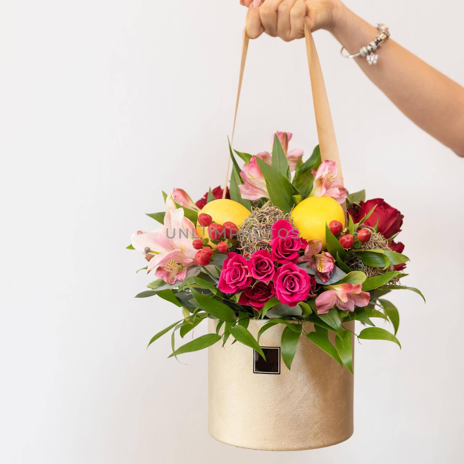 Woman holding colorful flower bouquet in the box with white background by ferhad