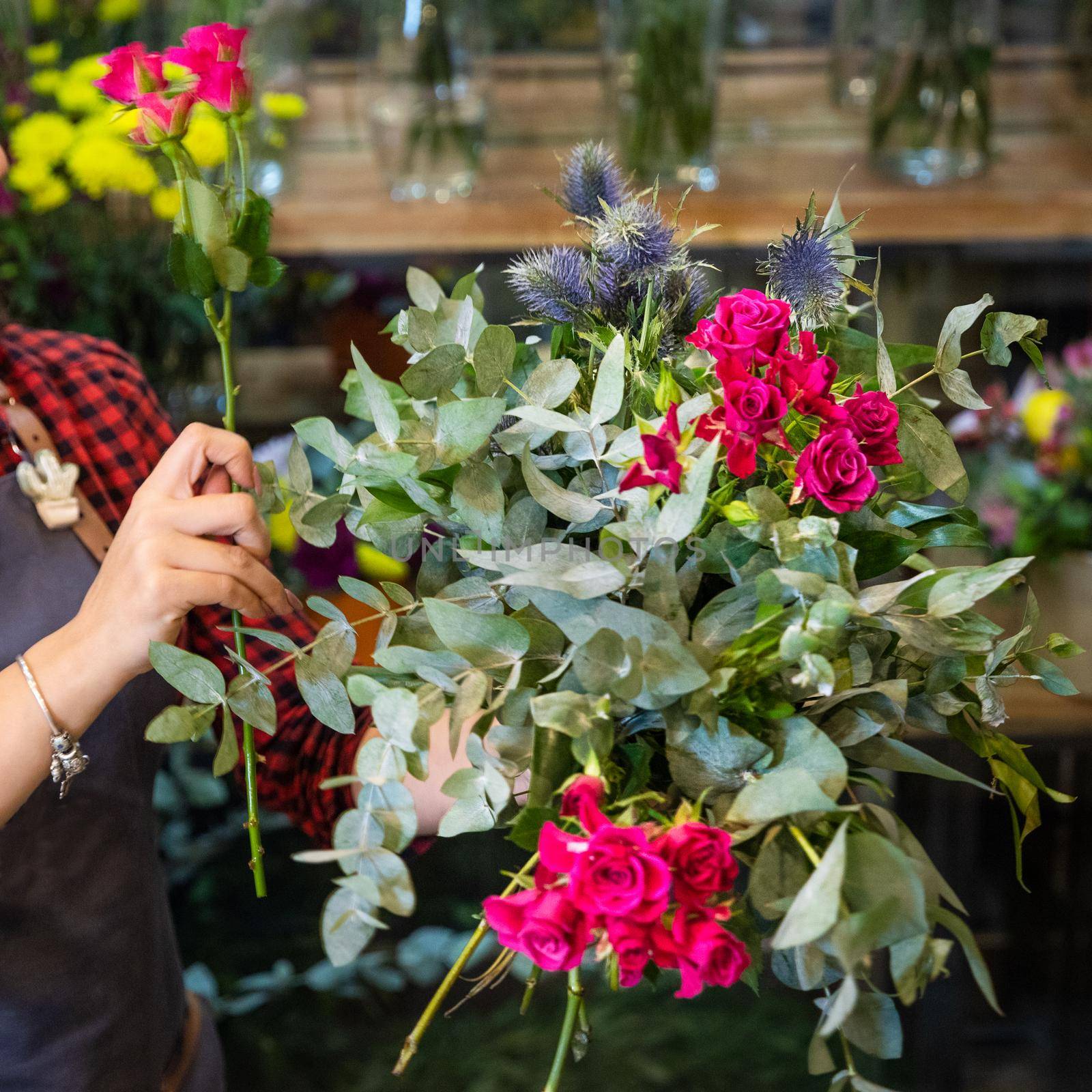 Florist woman making flower bouquet at the store