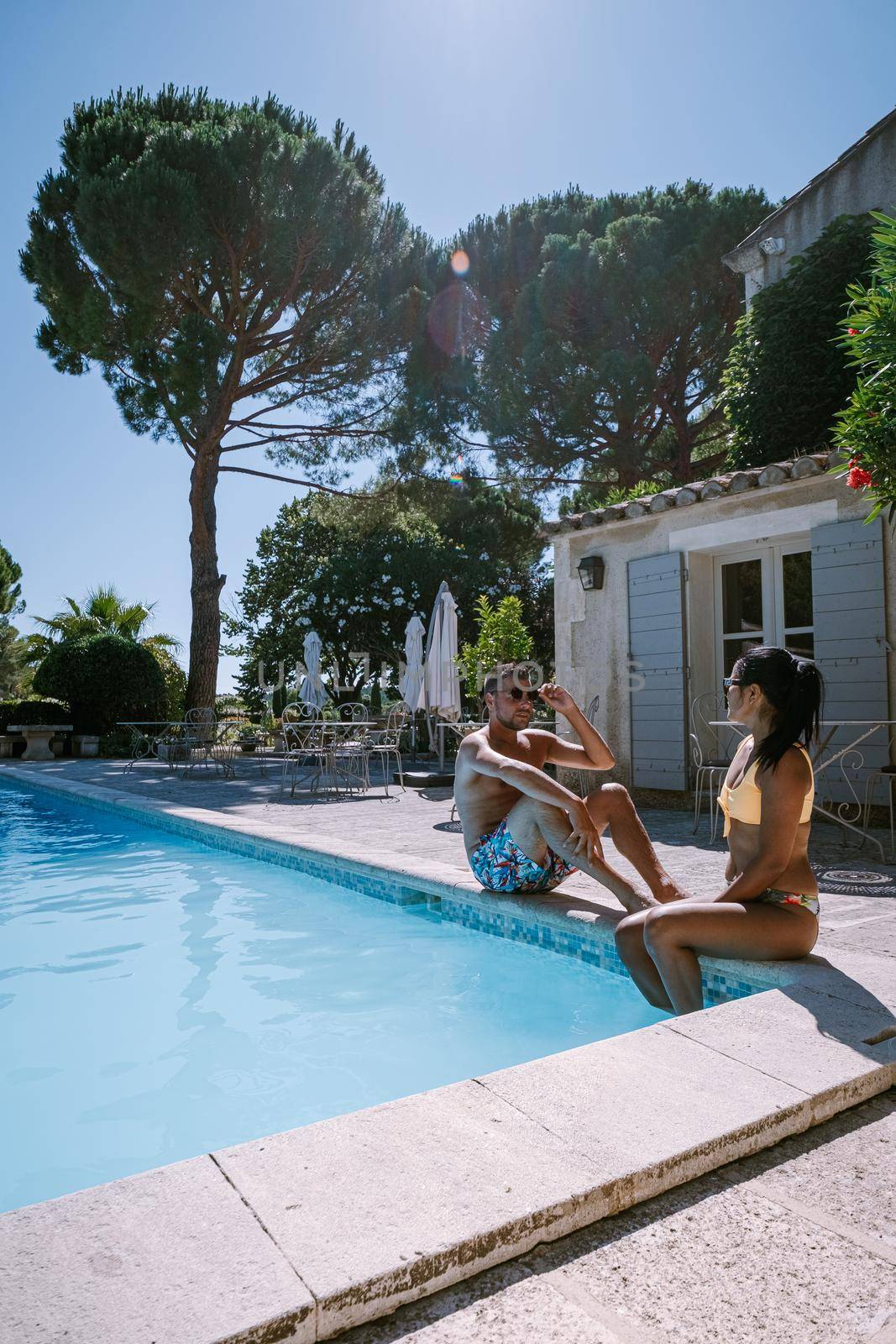 couple relaxing by the pool in the Provence France, men and woman relaxing by pool at luxury resort by fokkebok