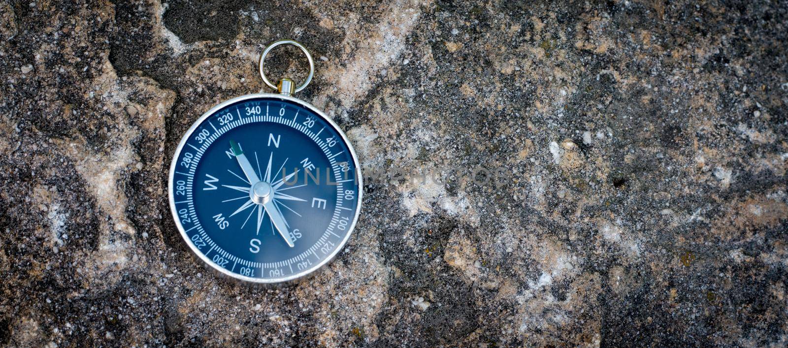 Vintage compass lying on the floor. Adventure and discovery concept.