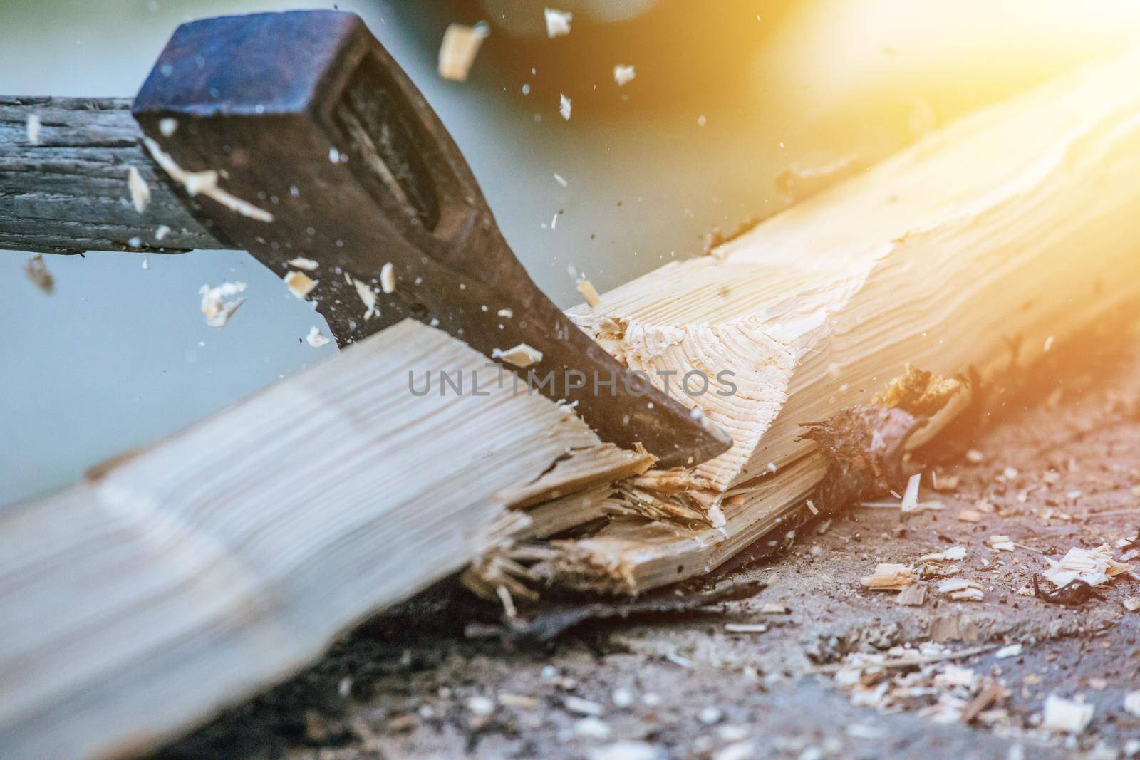 Sharpe axe is cutting wood for making fire, close up picture. Sunlight.