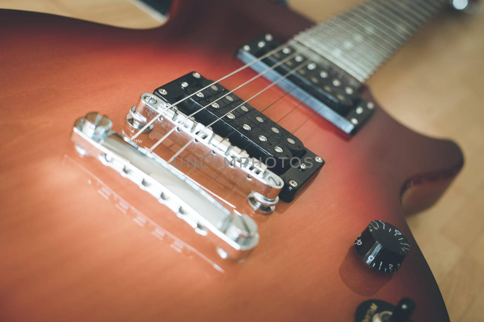 Electronic guitar in sunburst optic lying on the wooden floor